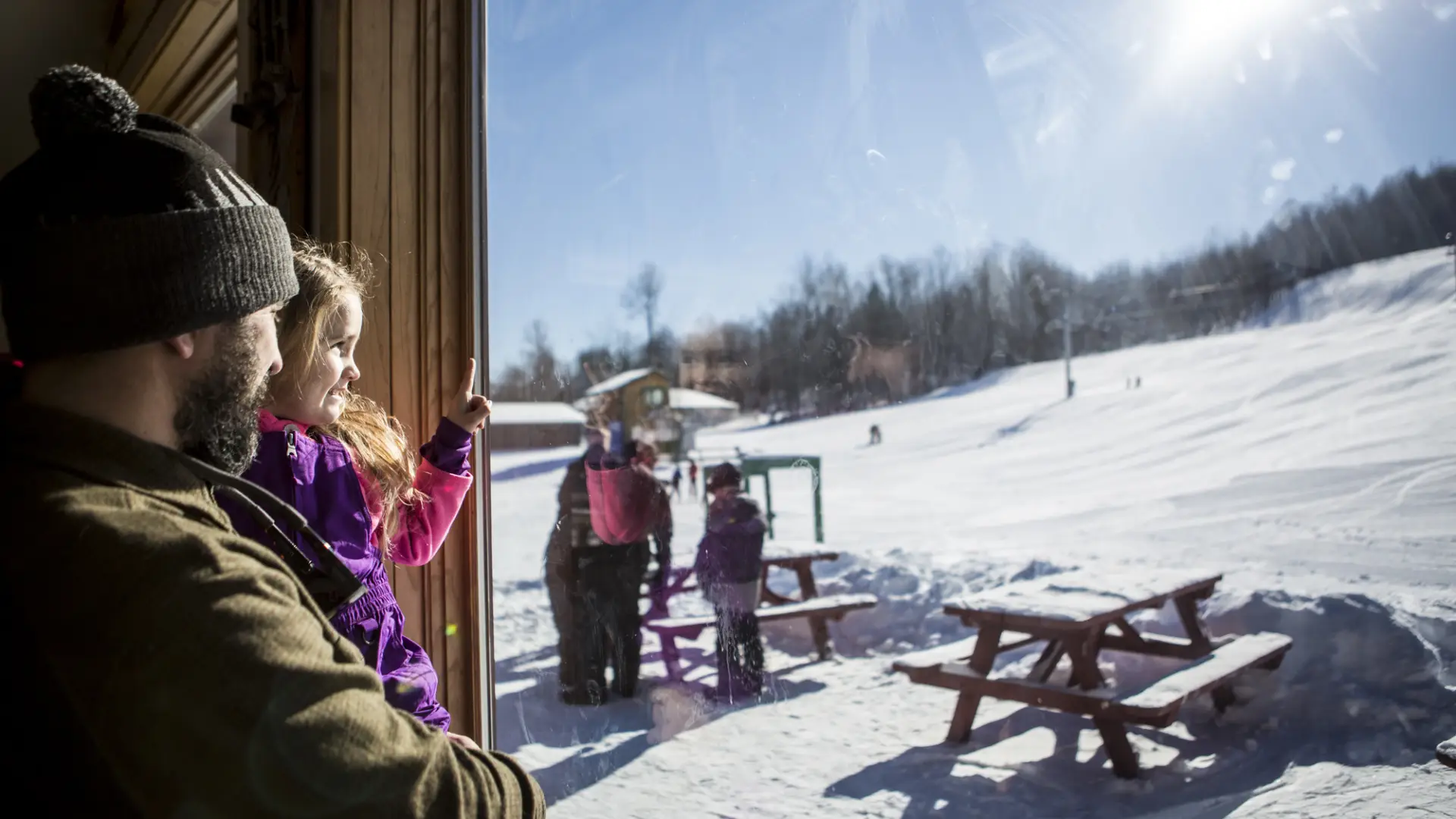 A dad holds his daughter inside the lodge at Pisgah