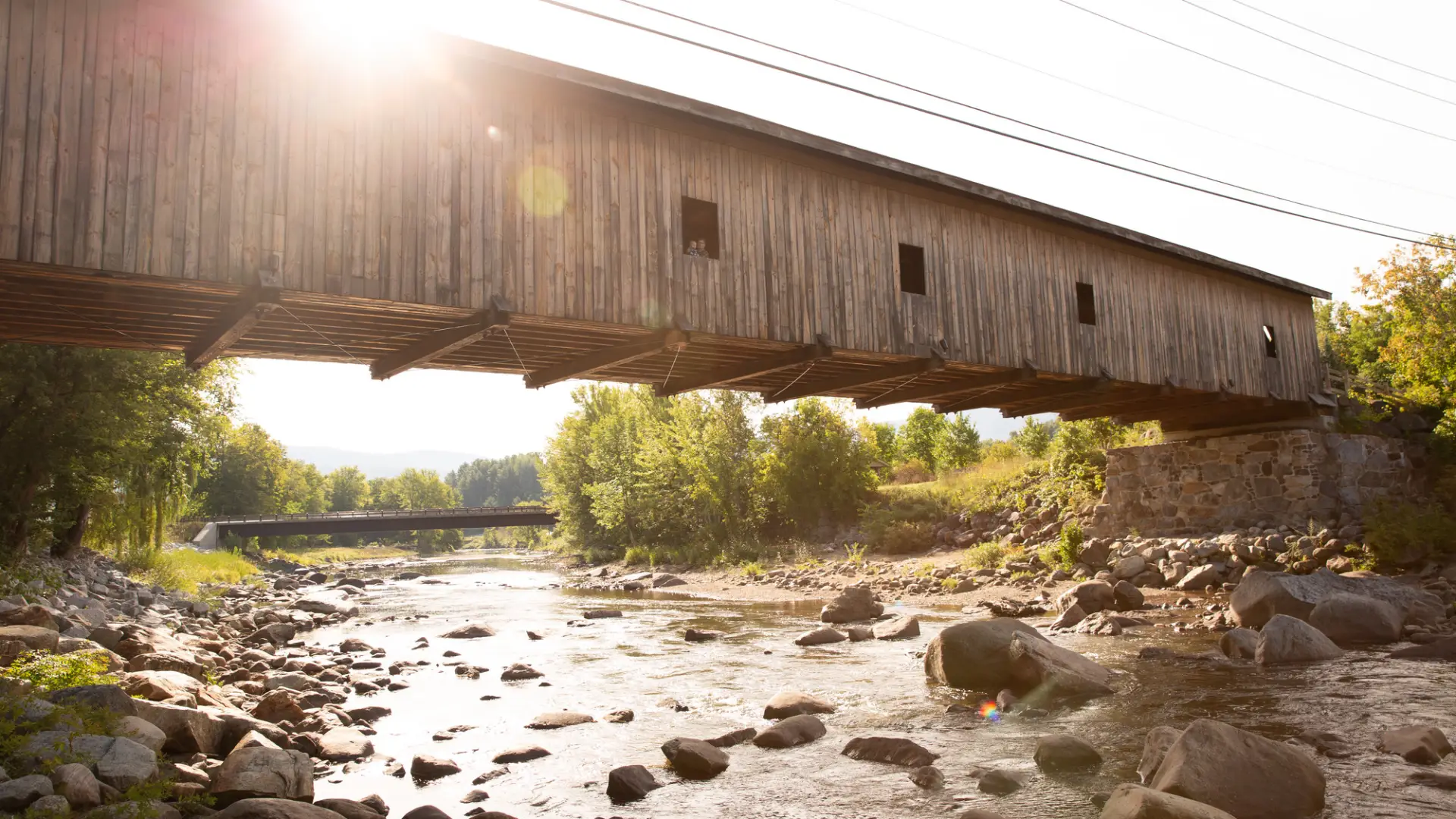 A covered bridge over a rocky stream