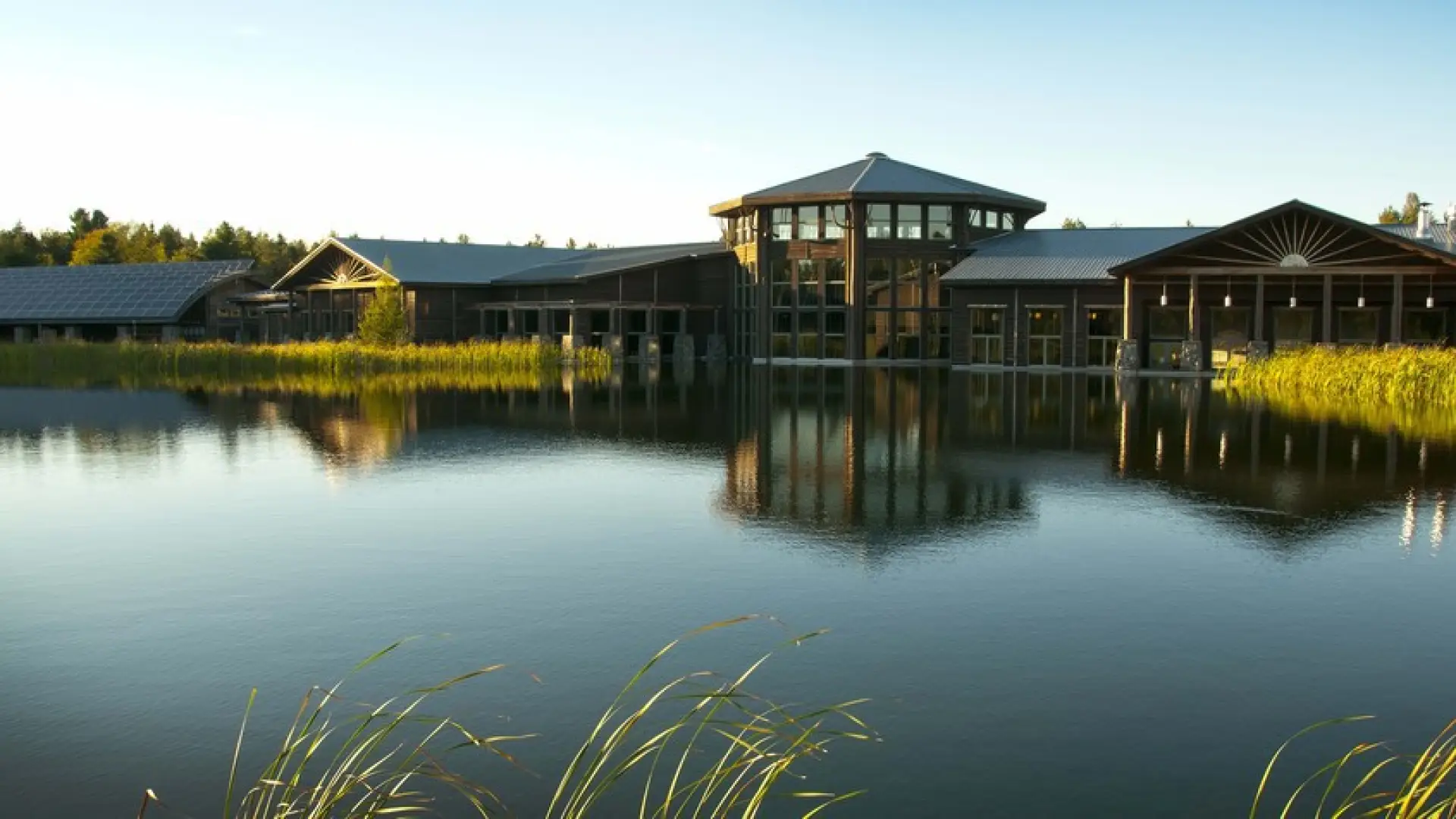 View of The Wild Center sitting across a shimmering body of water