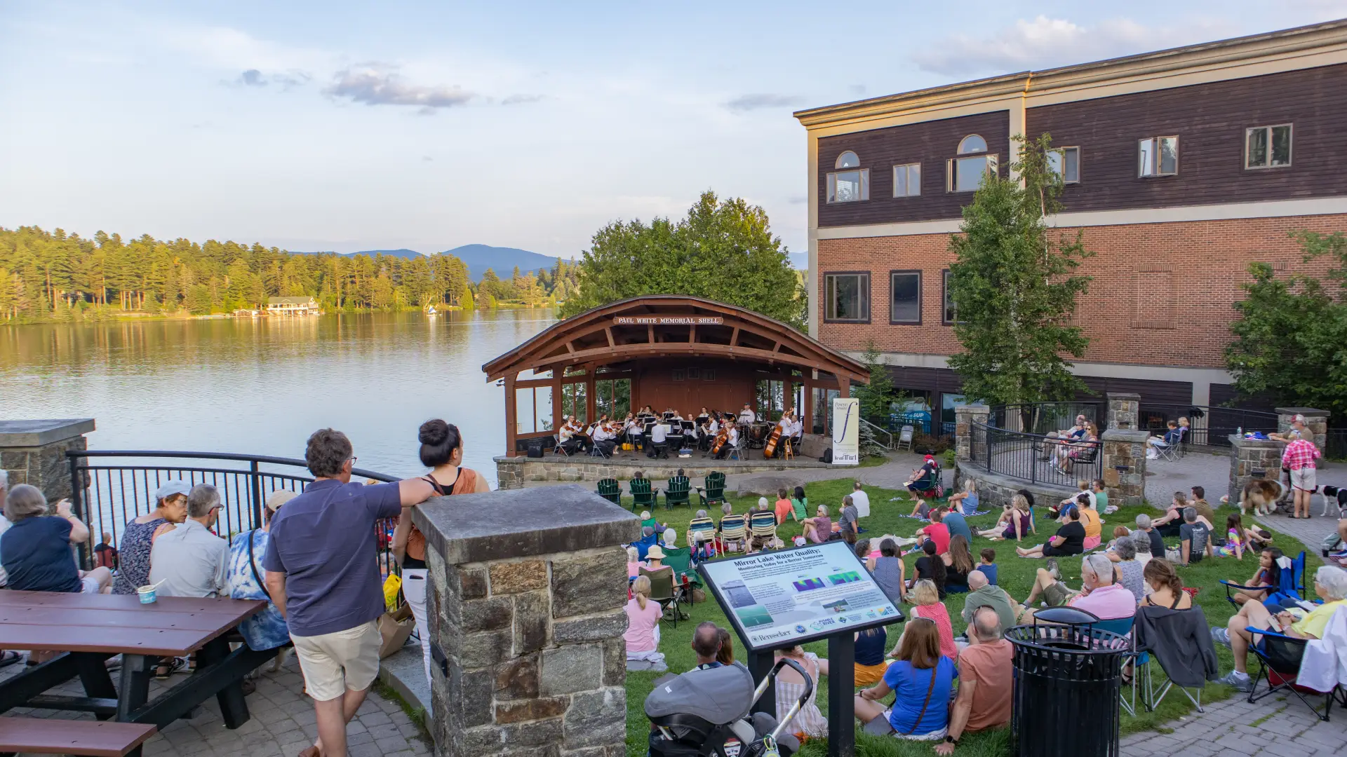 Park concert overlooking green with mountains and lake surrounding Credit to: Jacob Rushlow