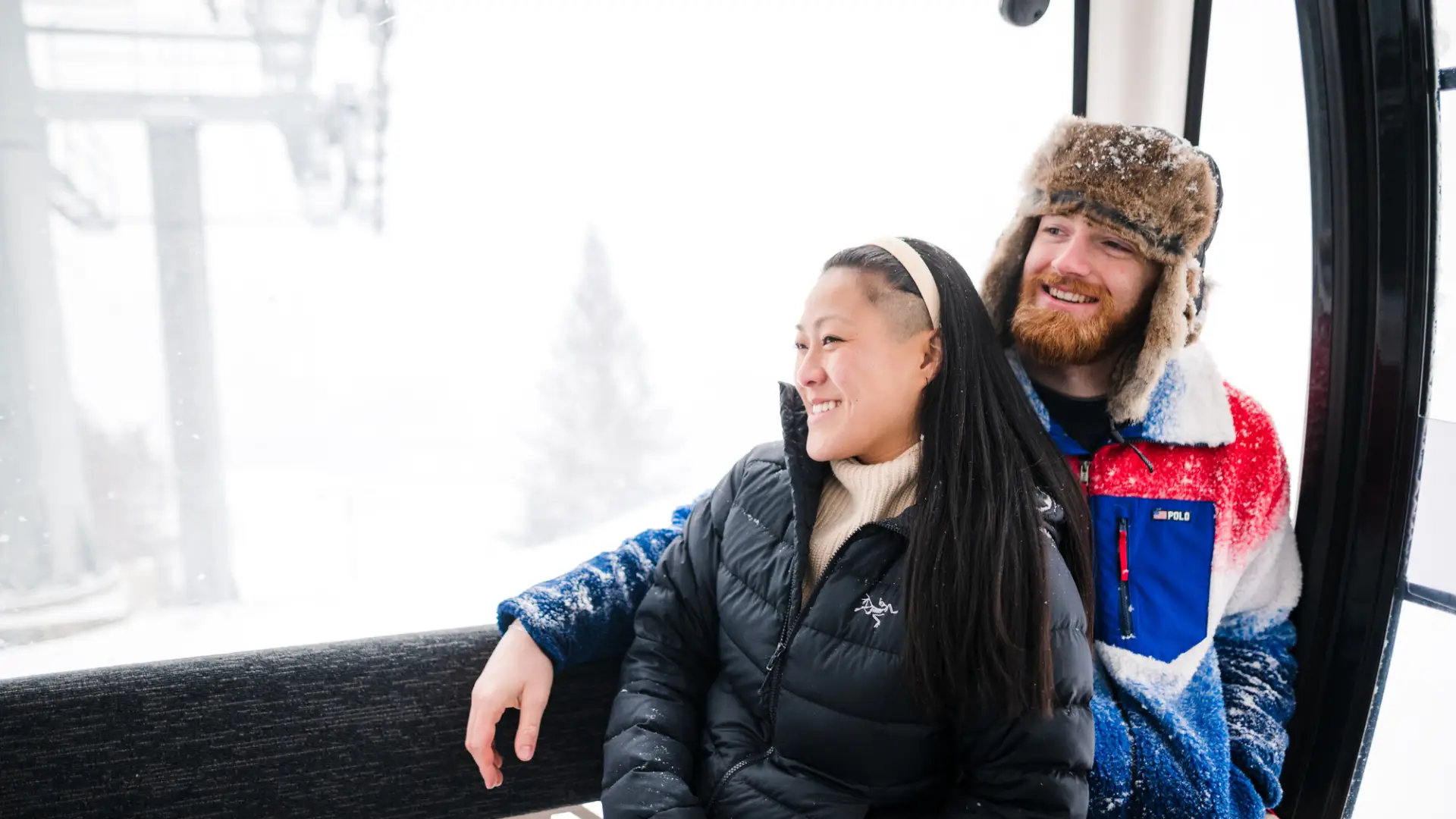 A couple rides the Sky Ride Gondola during the winter.