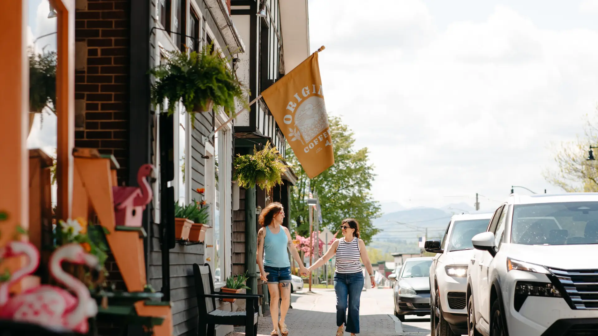 Two women walk down a main street.