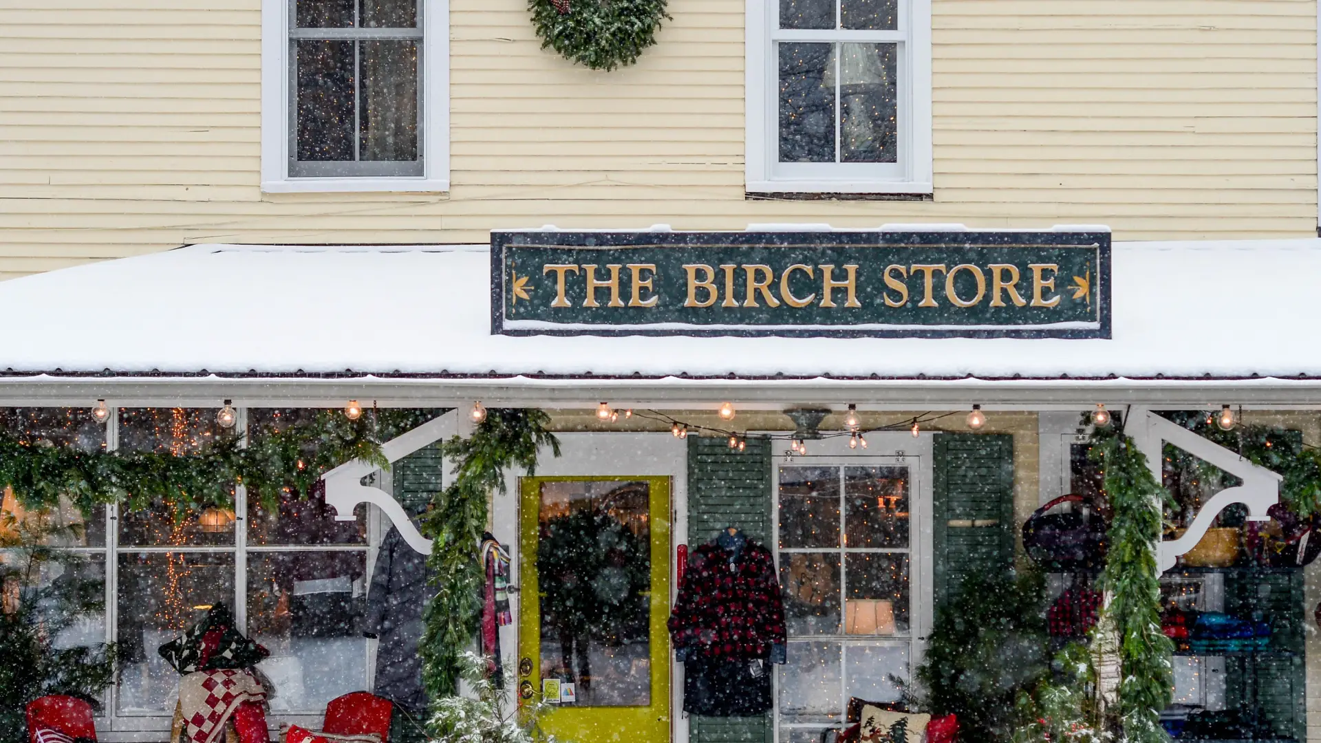 The exterior of The Birch Store blanketed in fresh white snow and decked out with garland for the holiday season