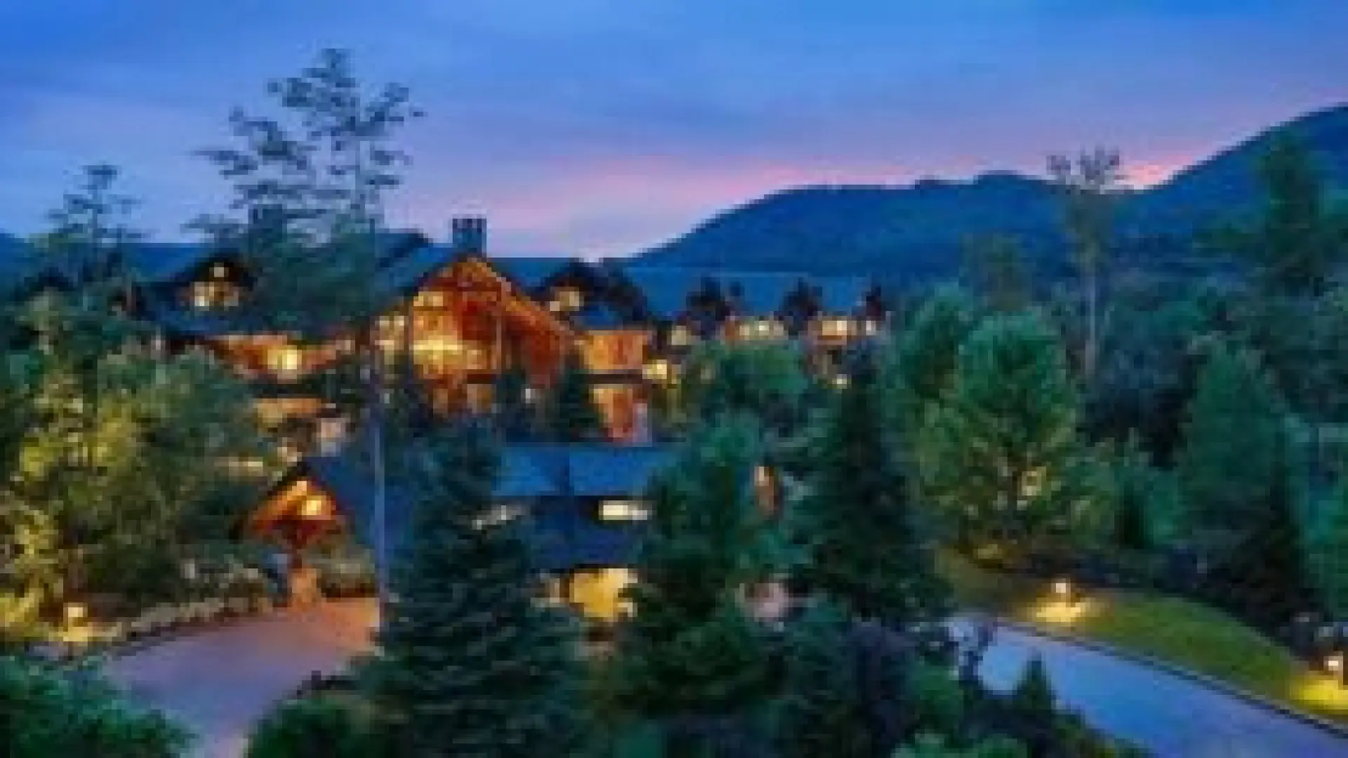 Whiteface Lodge Resort at dusk with outdoor lights illuminated 
