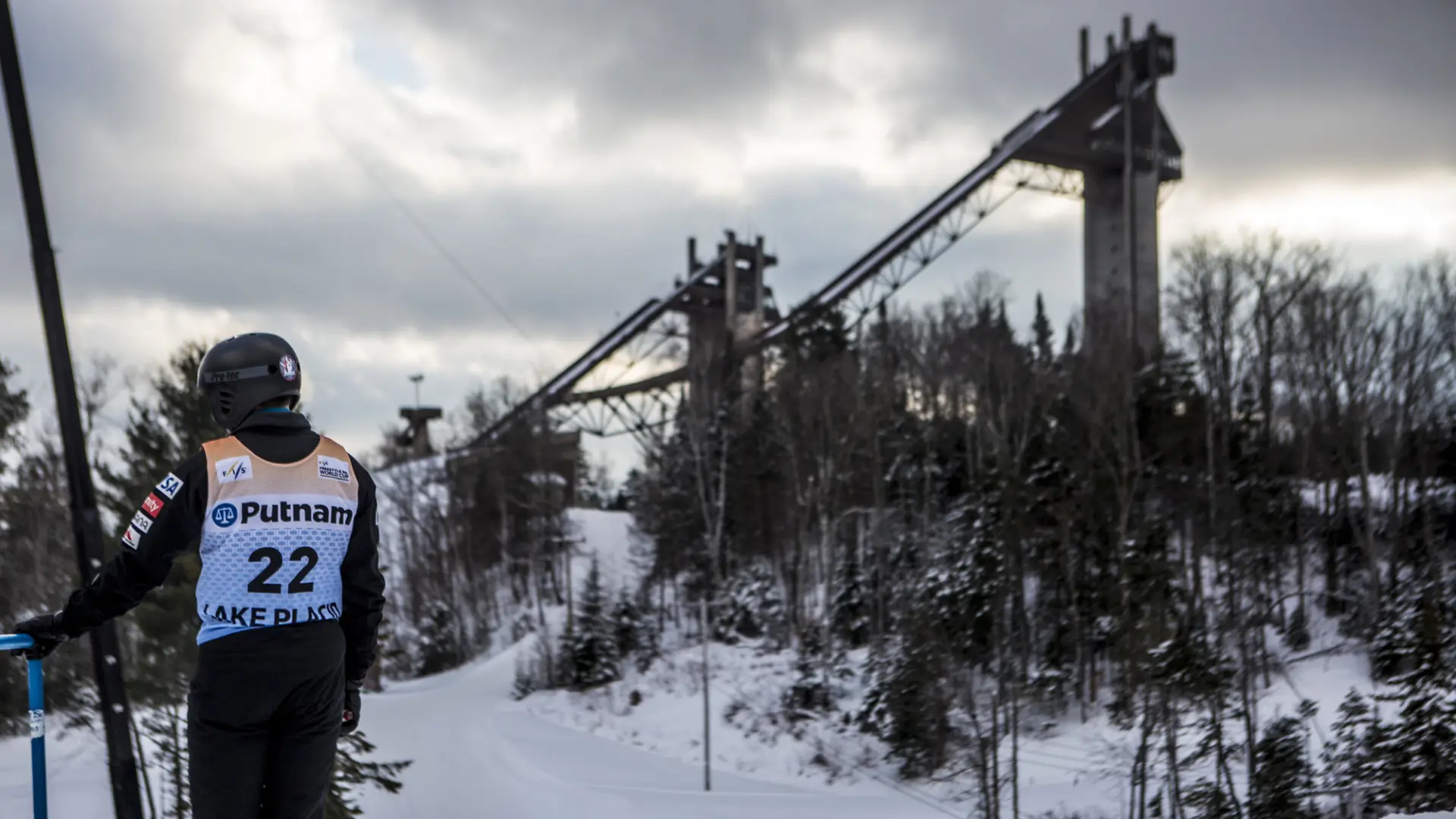 A ski jumper in competition stands before the jumps.