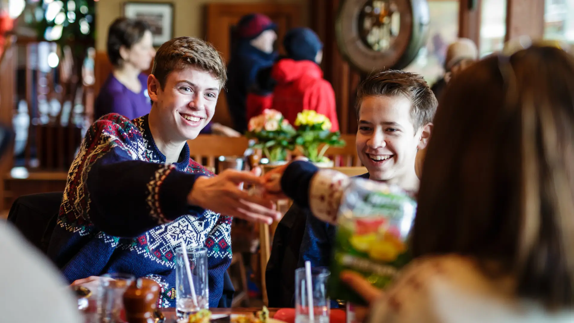 A family in sweaters cheerses their drinks.