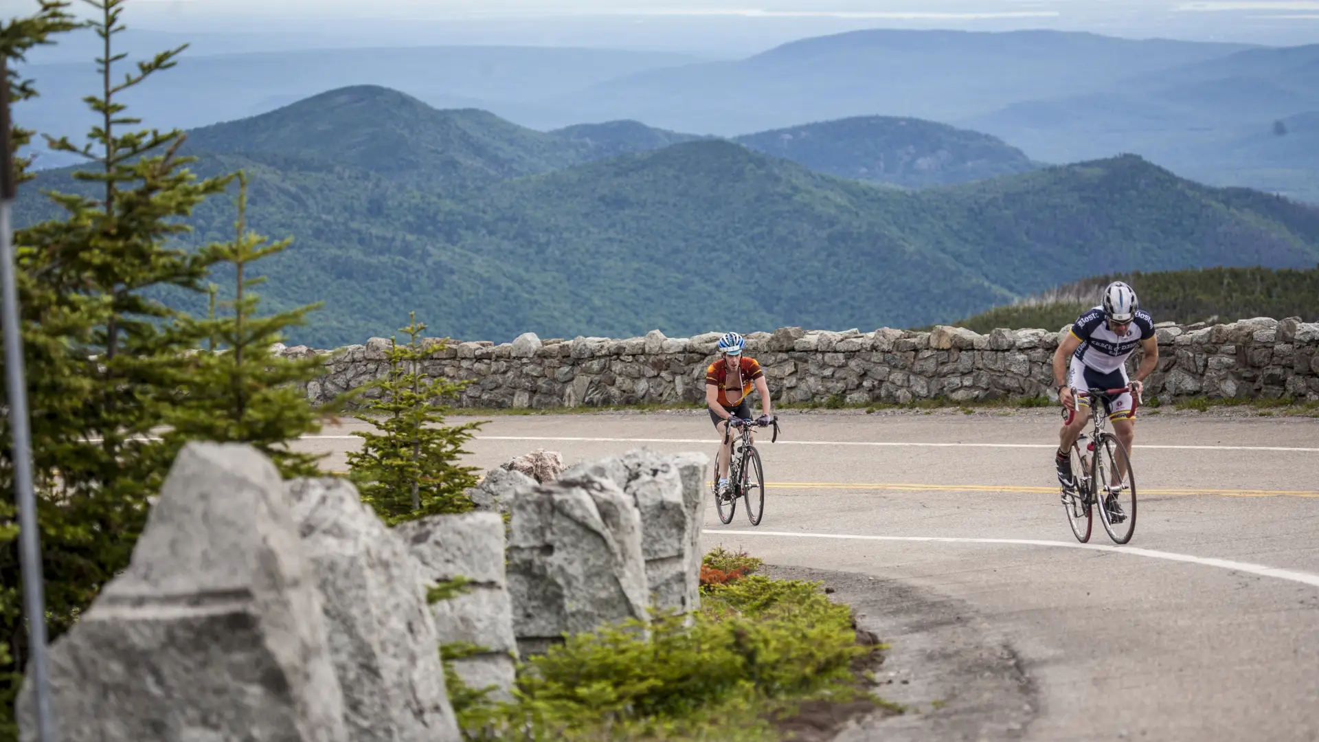 Two cyclists climb the Whiteface Toll Road.