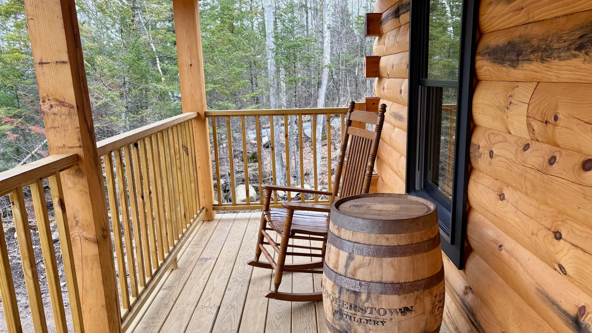 The covered porch with rocking chair and wine barrel table decor.