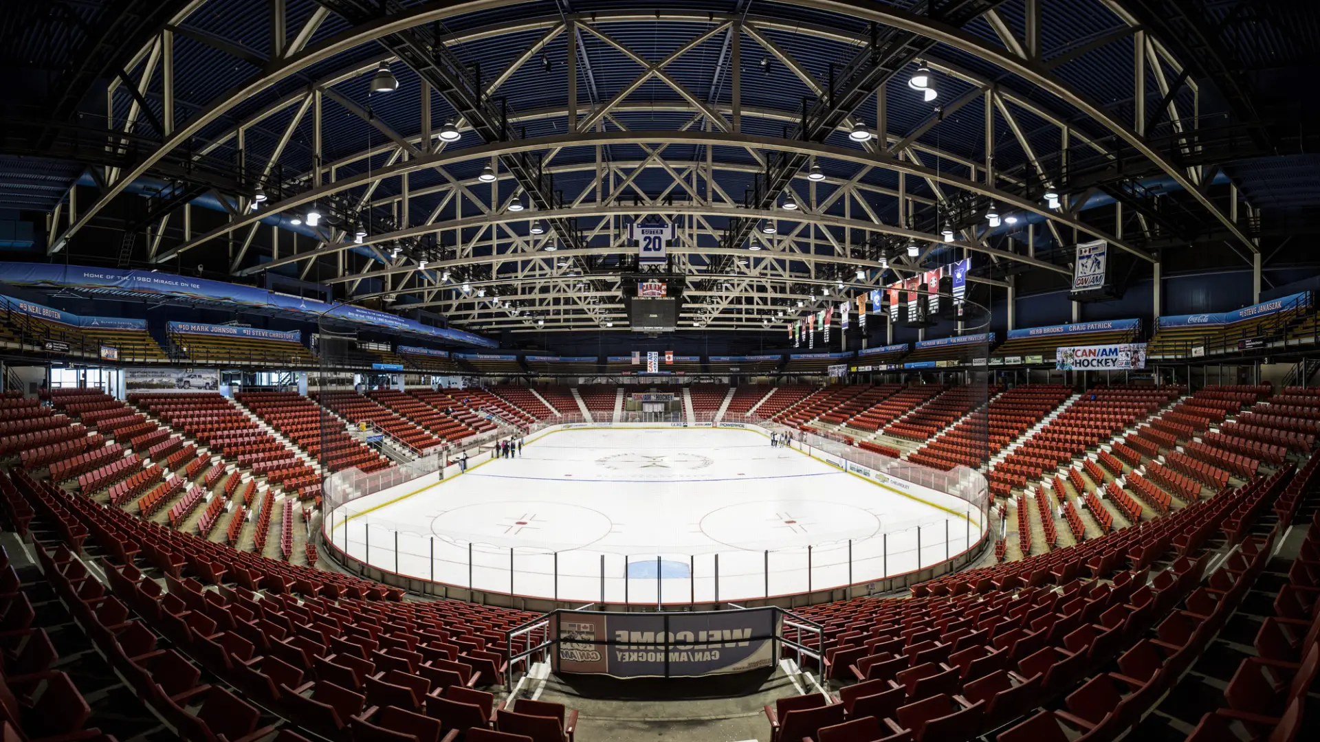 A panoramic view of a skating rink arena with red seats.