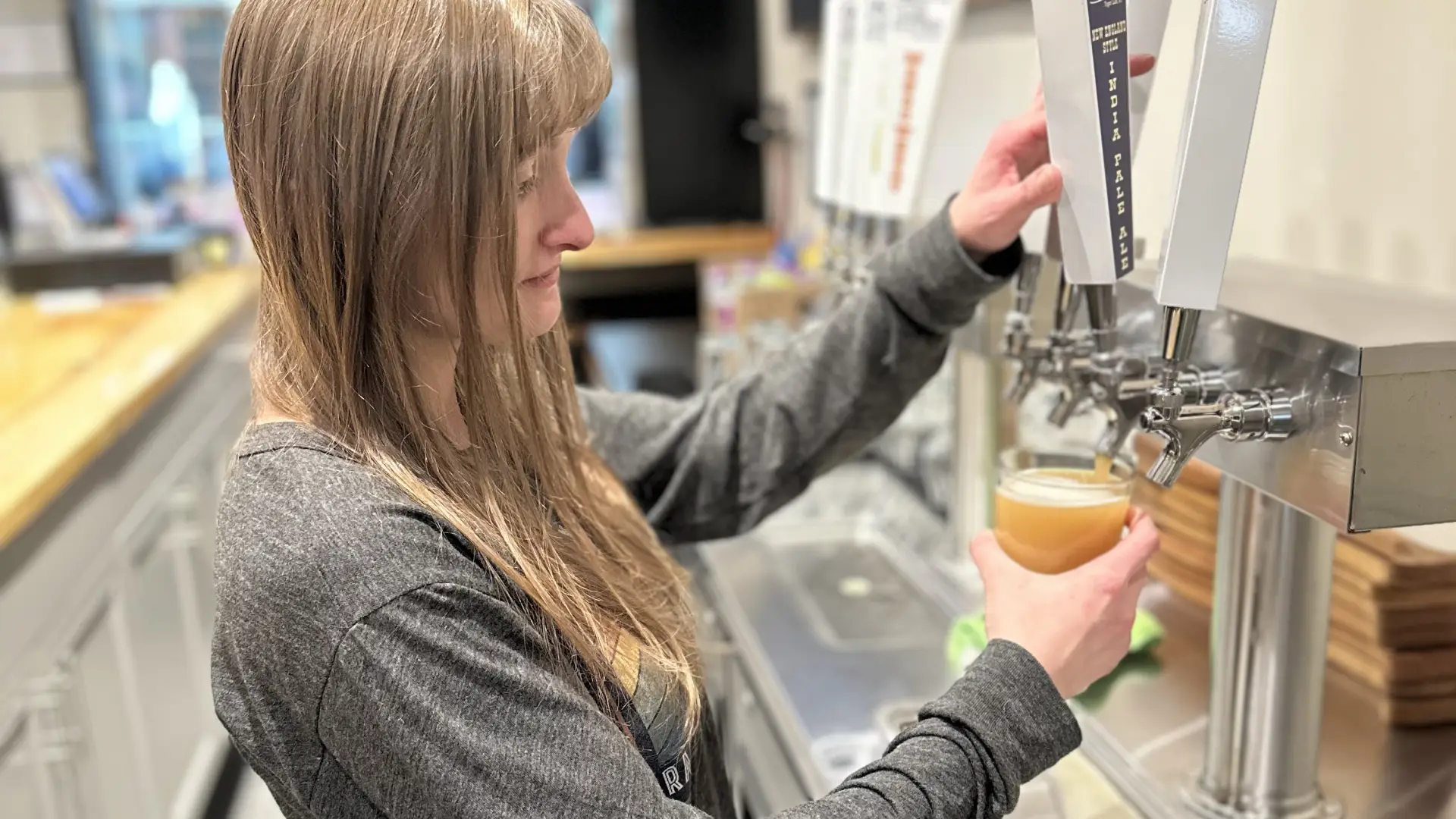 A woman pours a beer