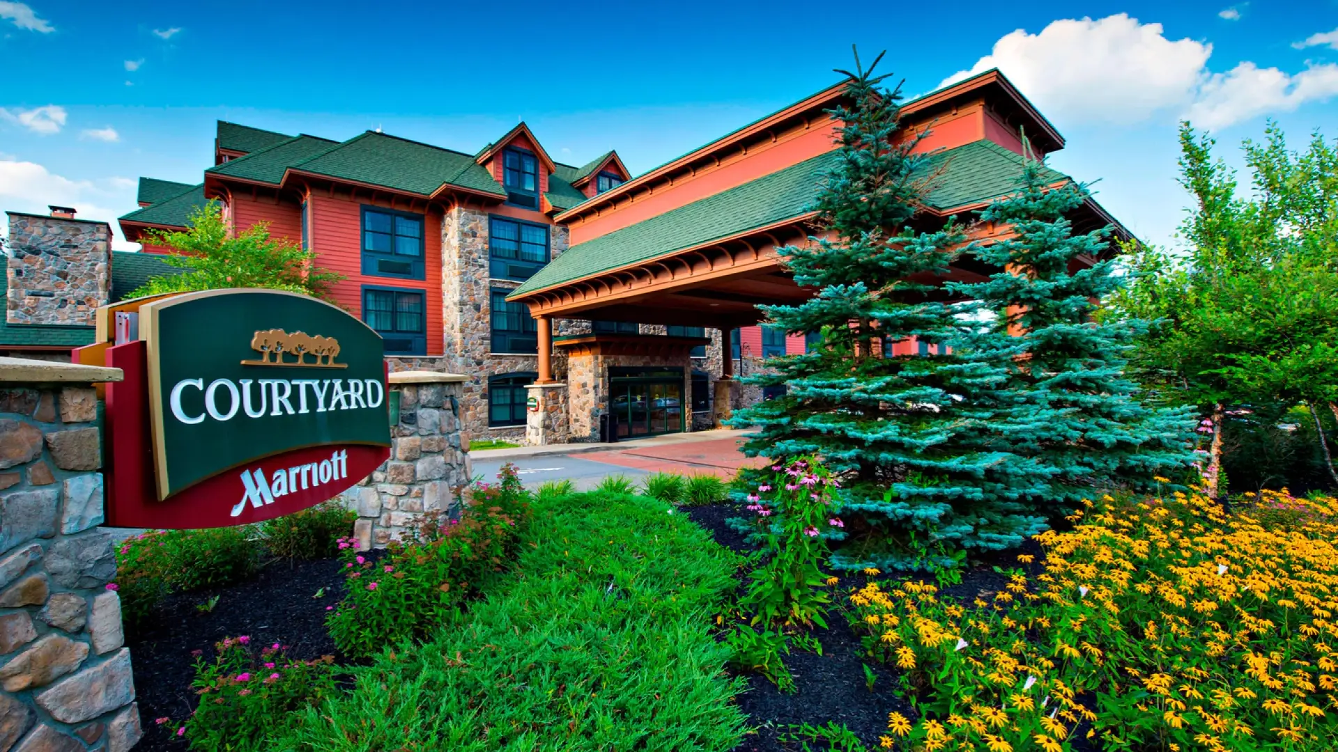 Exterior of the Courtyard by Marriott with entry sign and beautiful planting beds.