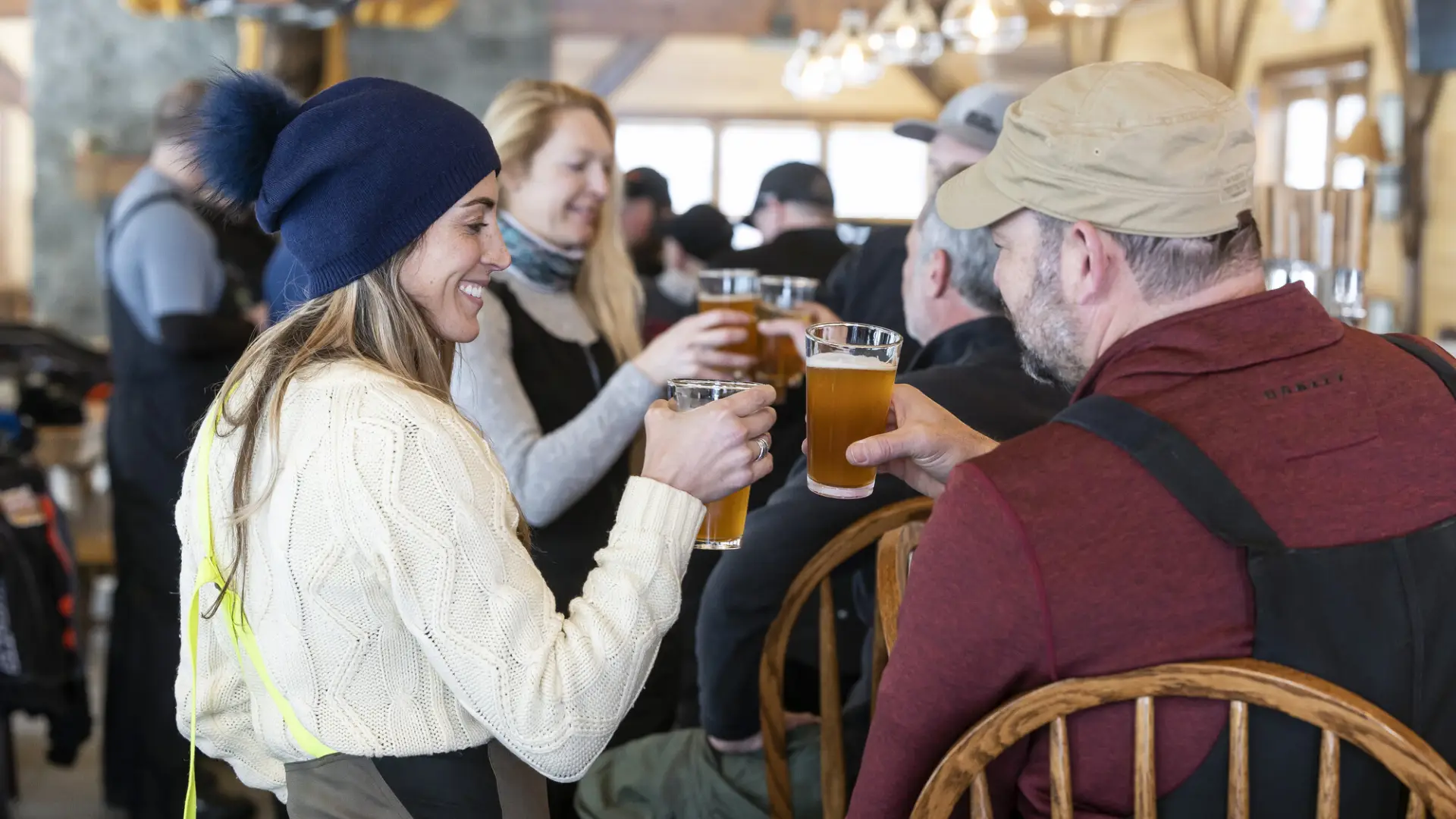 A group of people cheers drinks at a bar in winter.