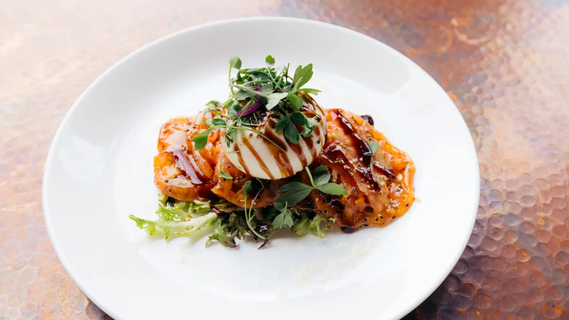 A close-up of a plate of fine dining food on a clean white plate.