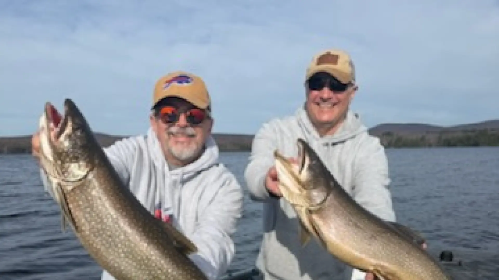 Two men each holding a huge fish.