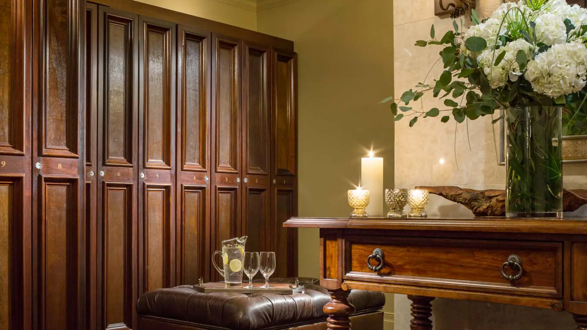 Dark wooden lockers and candles with leather seats appoint the men's lockerroom