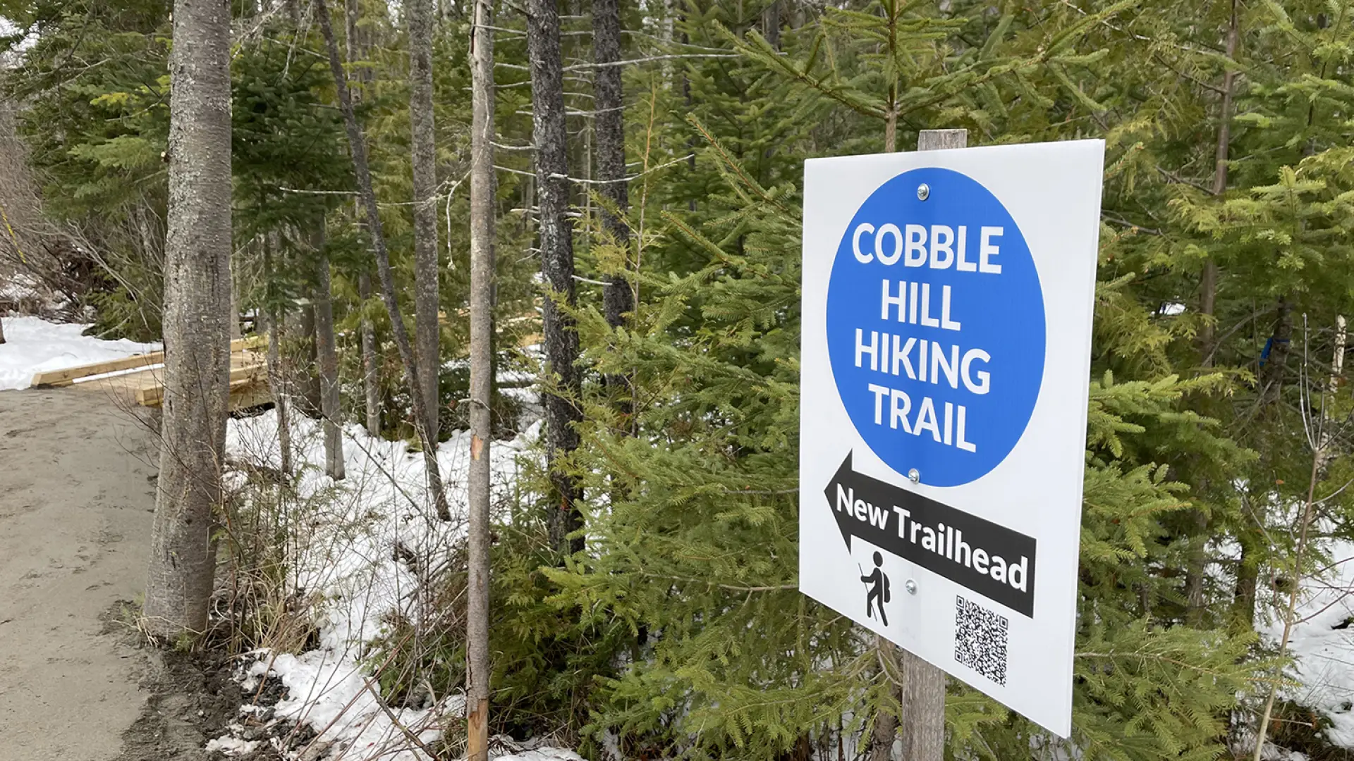 A blue and white sign for the new Cobble Hill Hiking Trail.