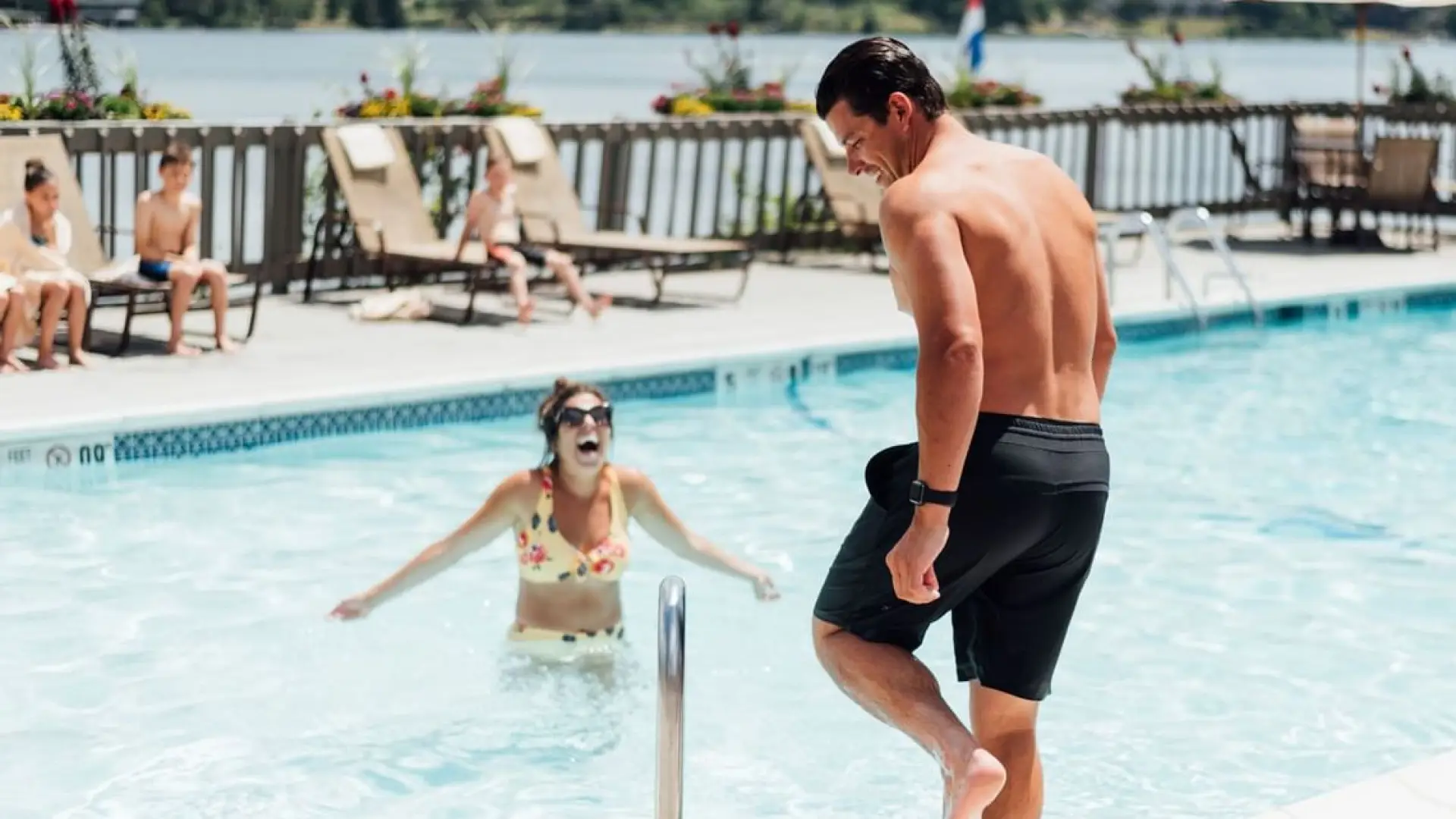 A happy couple plays in the pool overlooking Mirror Lake