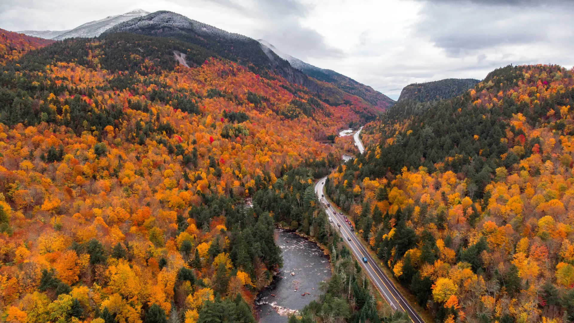 A fall aerial view of a mountain road between mountains