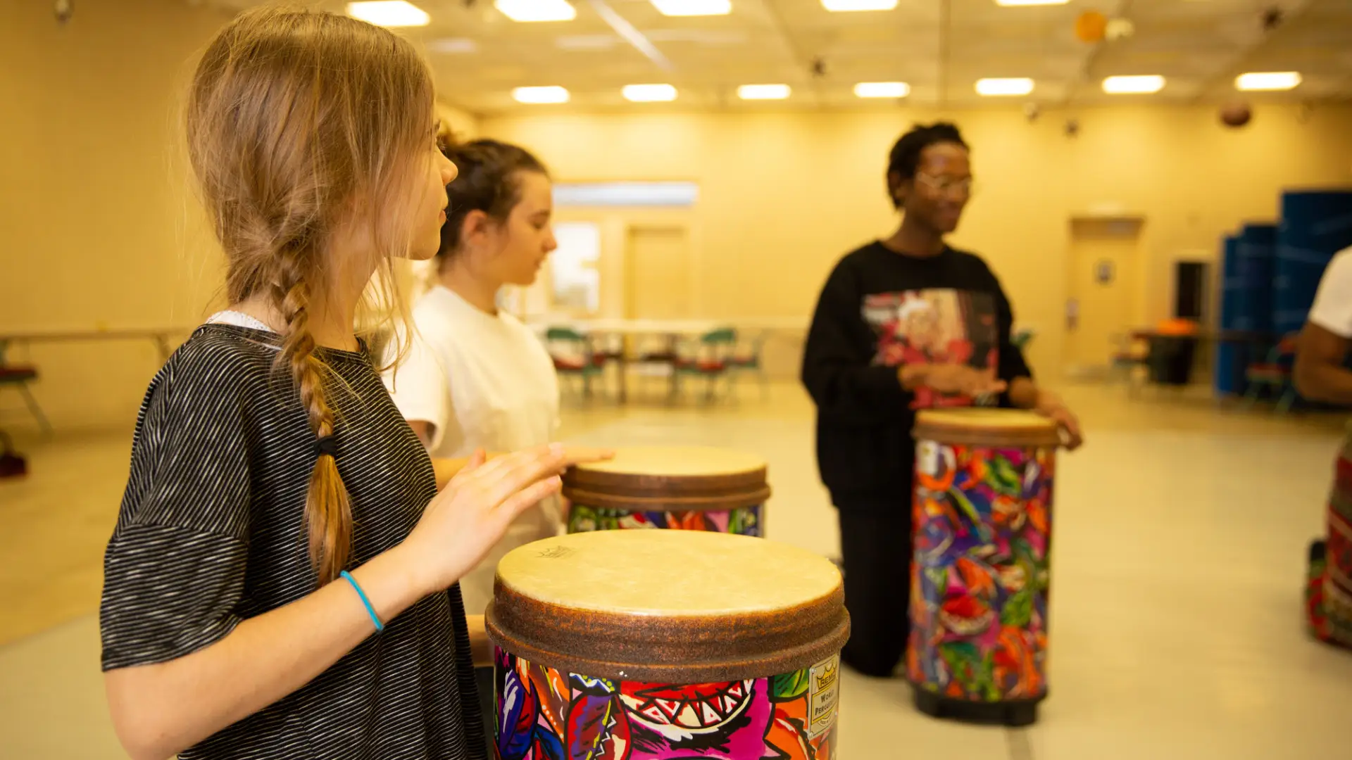 Three people in a bongo drum workshop.