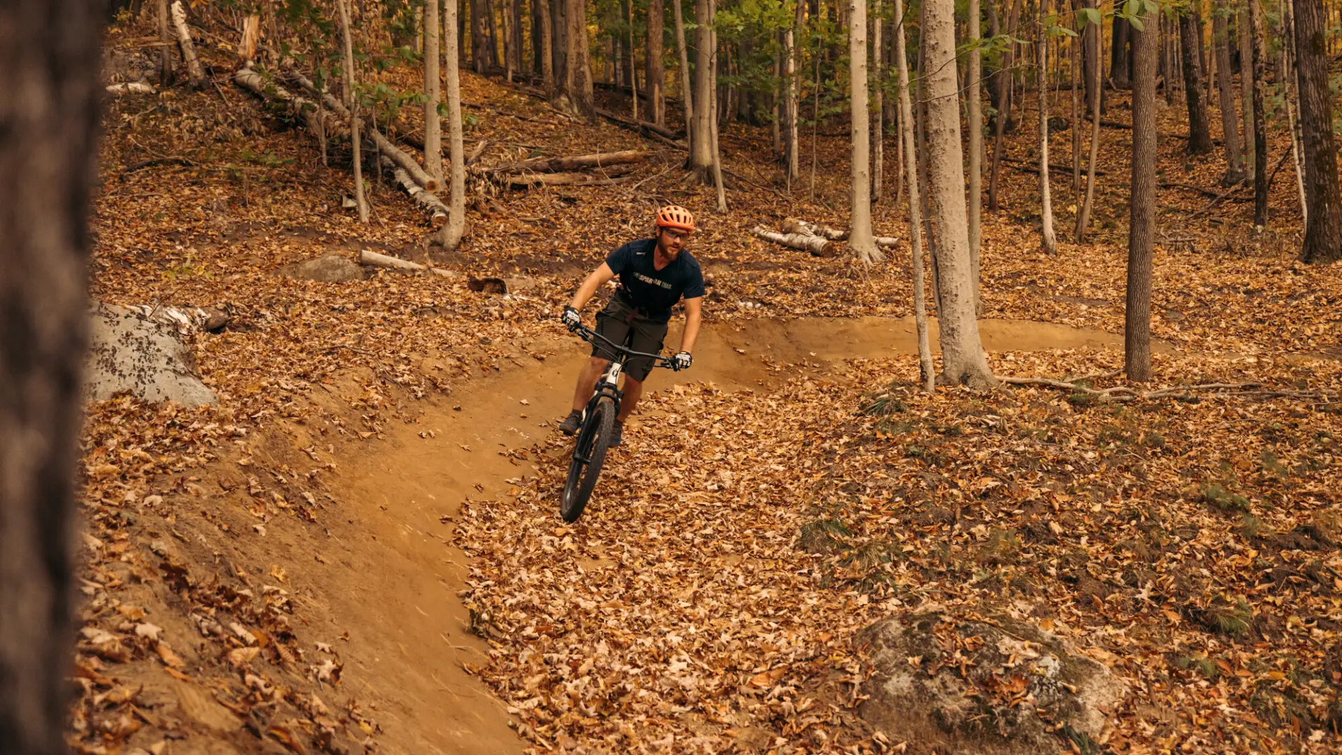 Mountain bikers rides leaf-covered trail