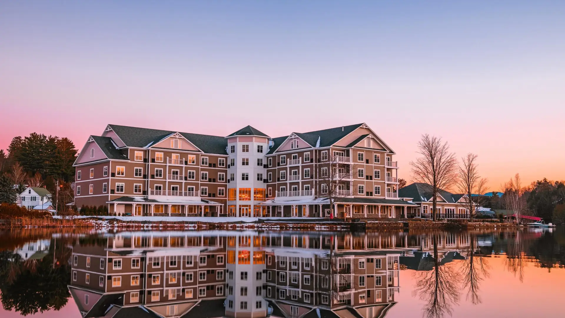The exterior reflects off Lake Flower in a pink sunset