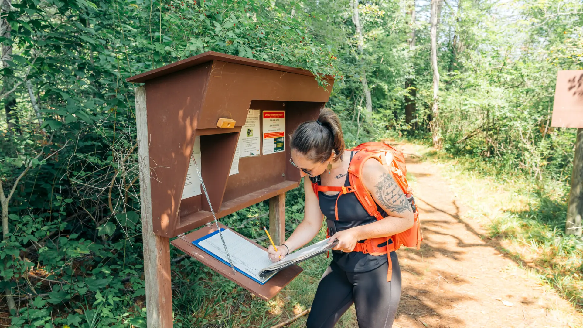Hiker signs in at Rooster Comb trail register