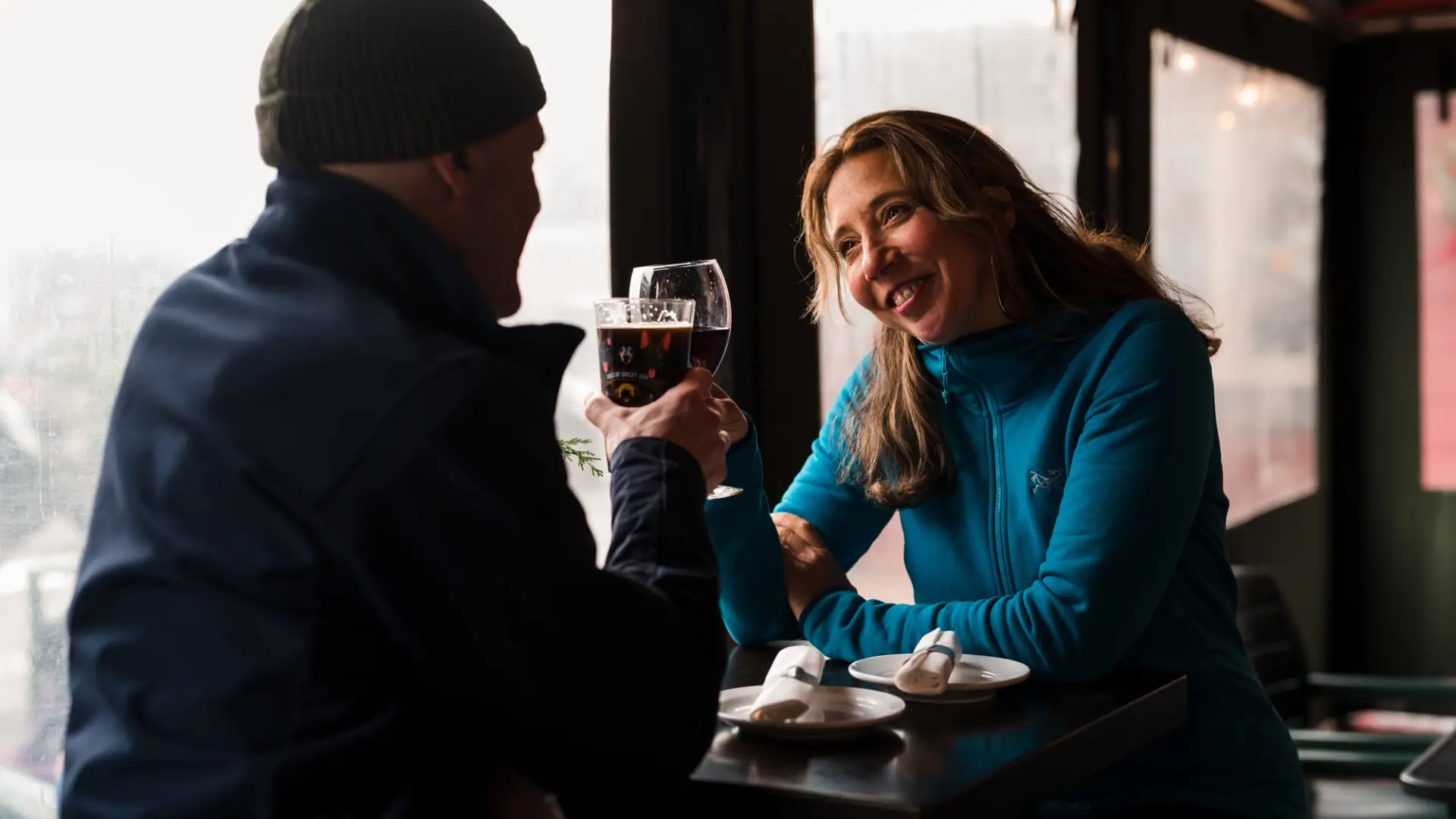 A couple sits window-side at a restaurant.