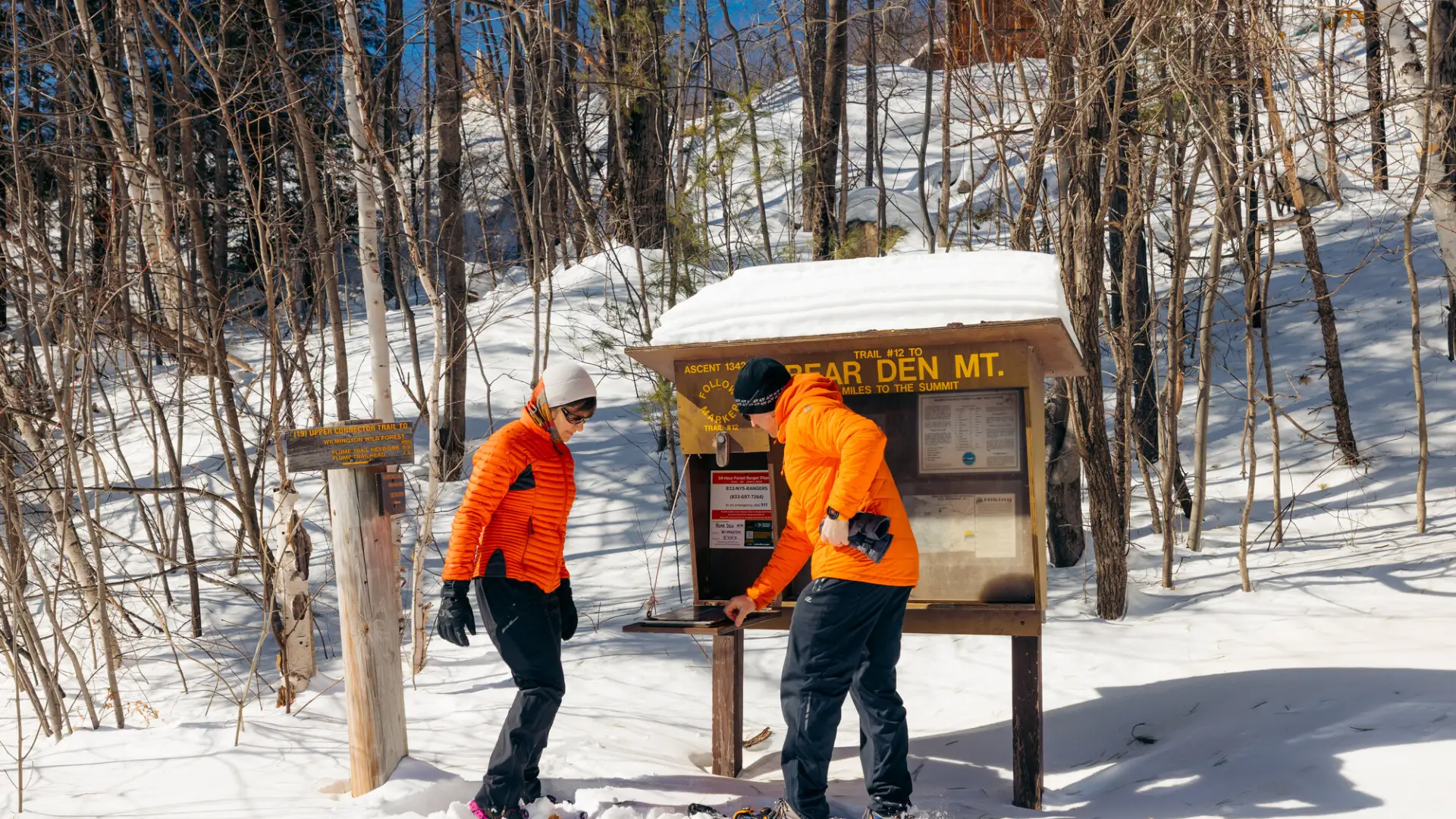 Two snowshoers signing into the Bear Den trail register