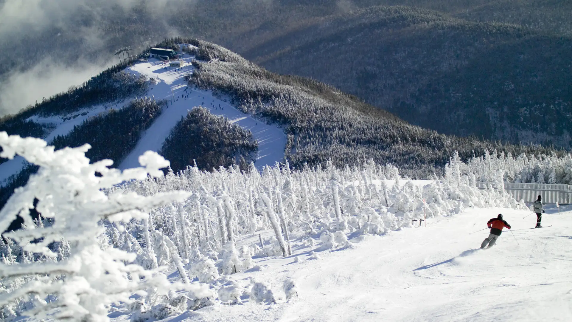 A frosty snow-covered mountain with ski trails carved into it.