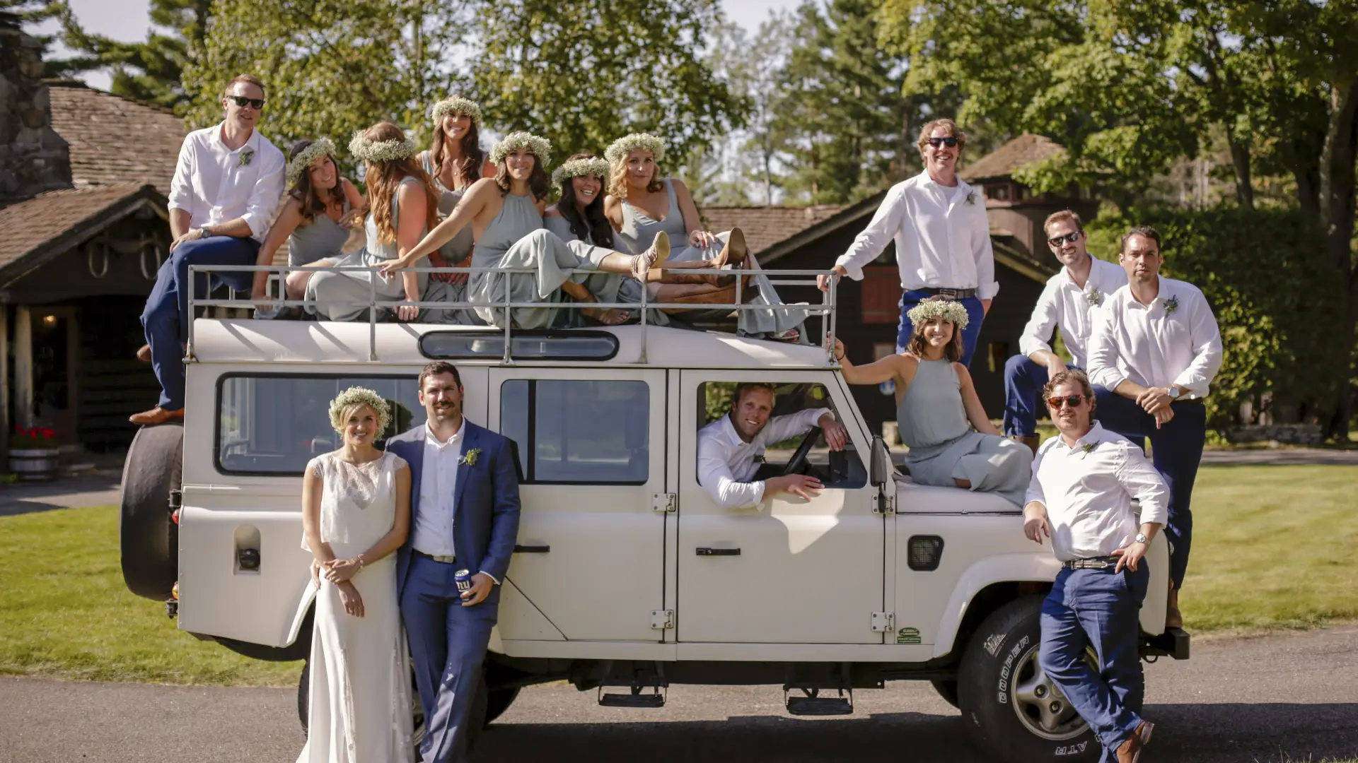Wedding party posed around an antique safari truck