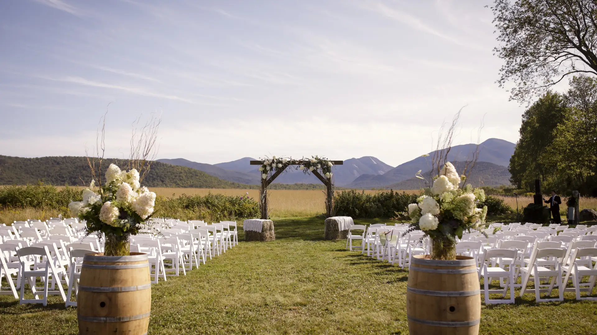 The wedding site with rustic alter adorned with hydrangeas and hay bales