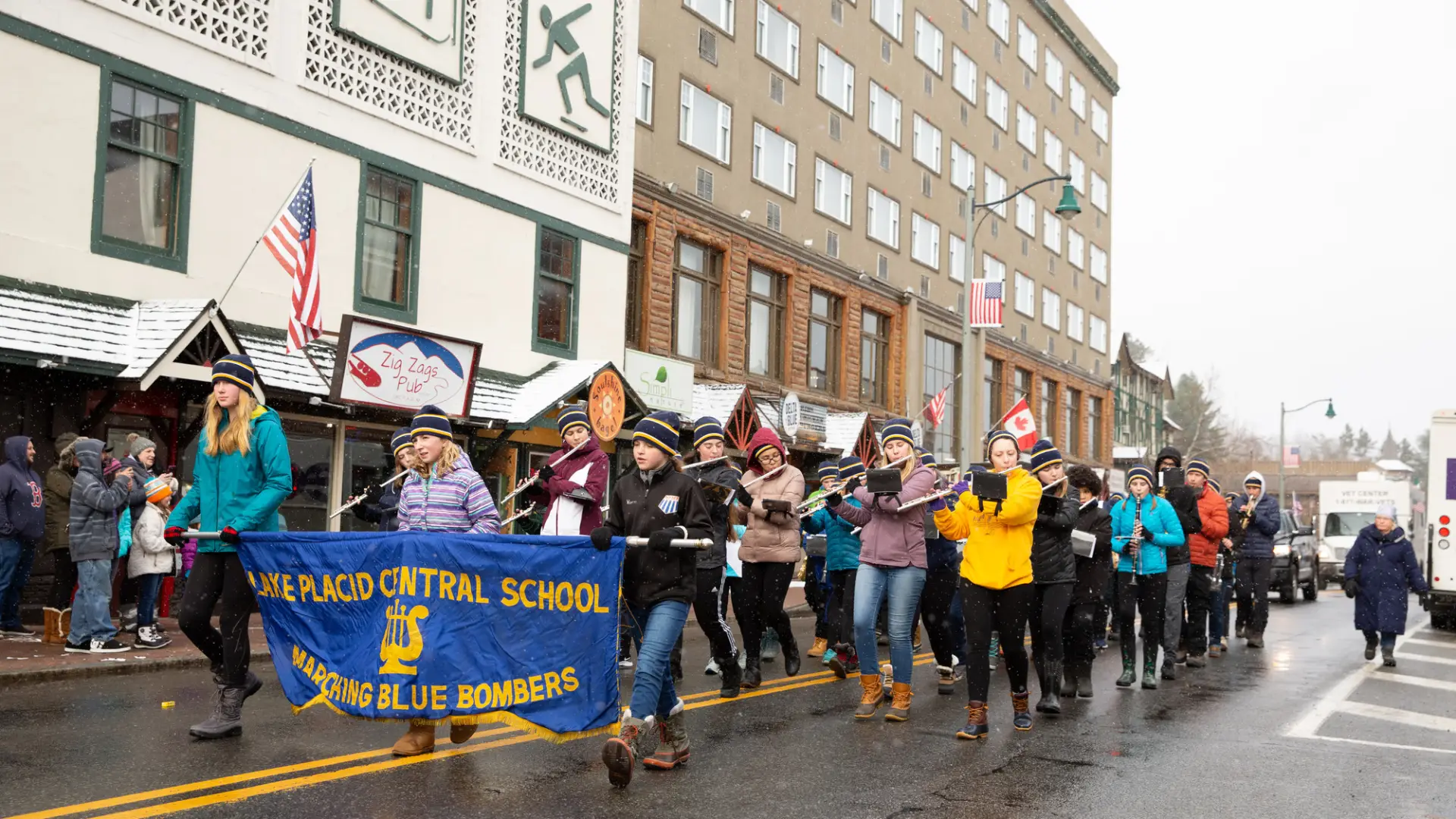 A high school band plays on Main Street in the snow.