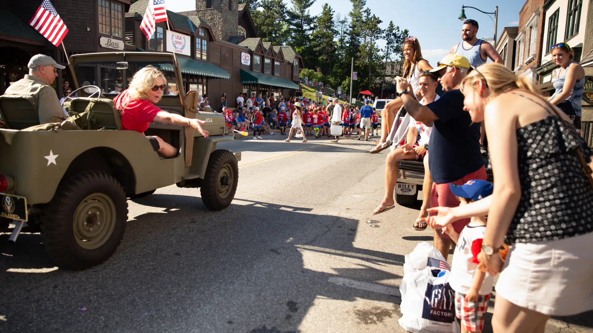 Car drives past parade crowd on Main Street in Lake Placid