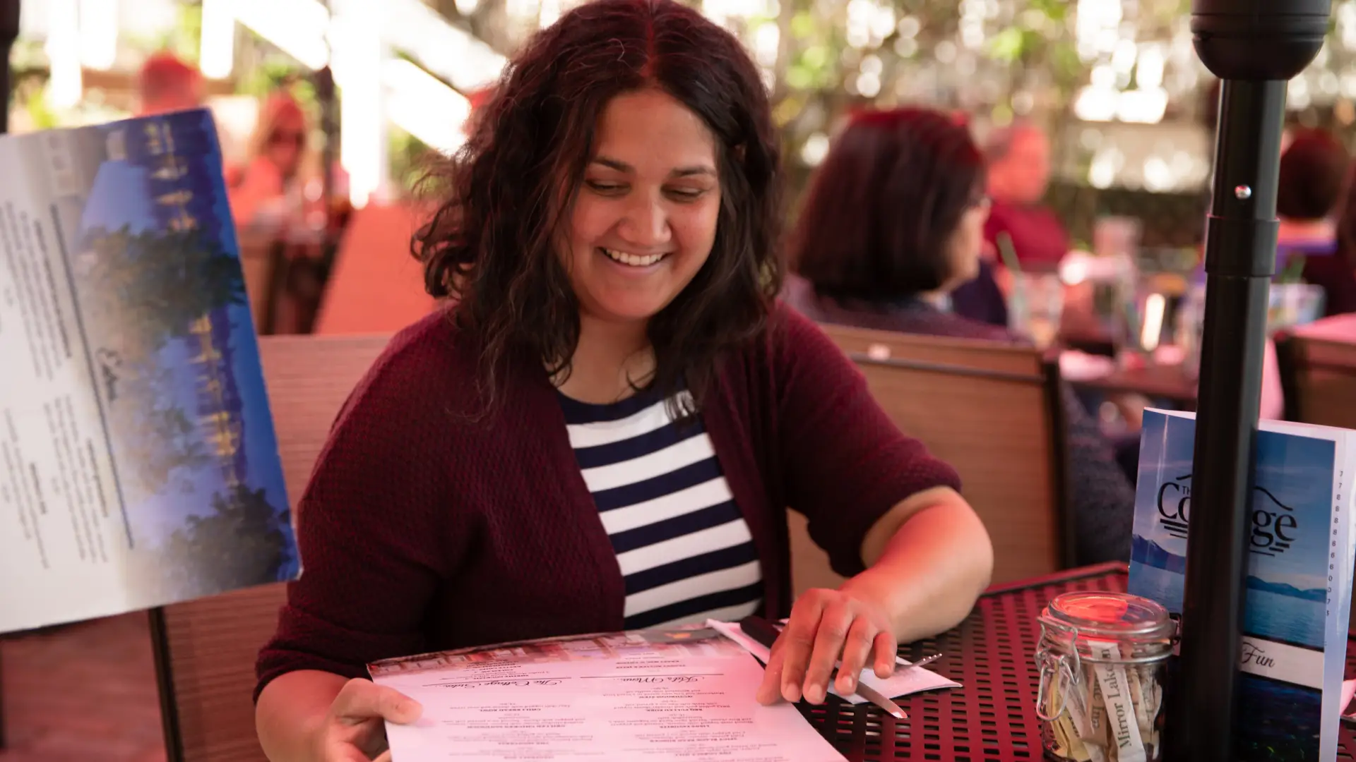 A woman studies the menu at The Cottage's outdoor dining area.