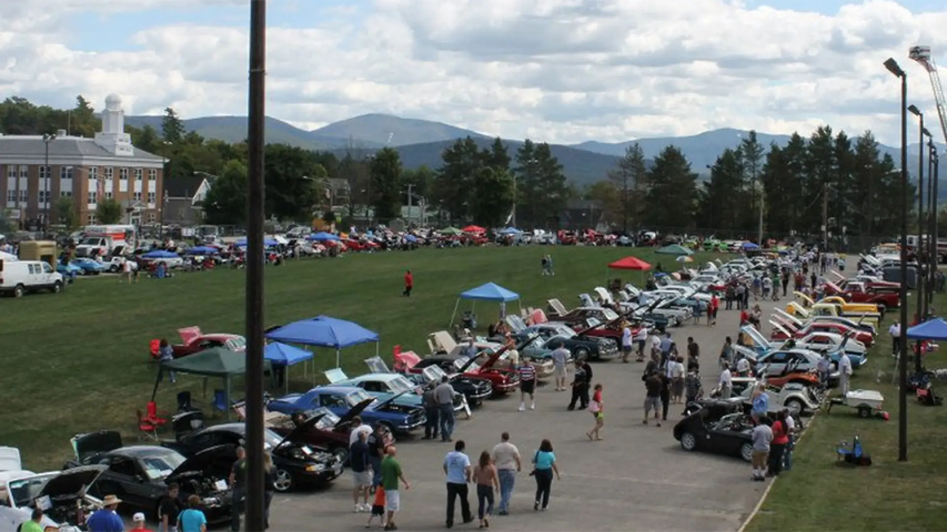 Cars lined up around the Lake Placid speedskating oval for the Annual Olympic Car show, benefiting the Lake Placid Ski Club youth programming