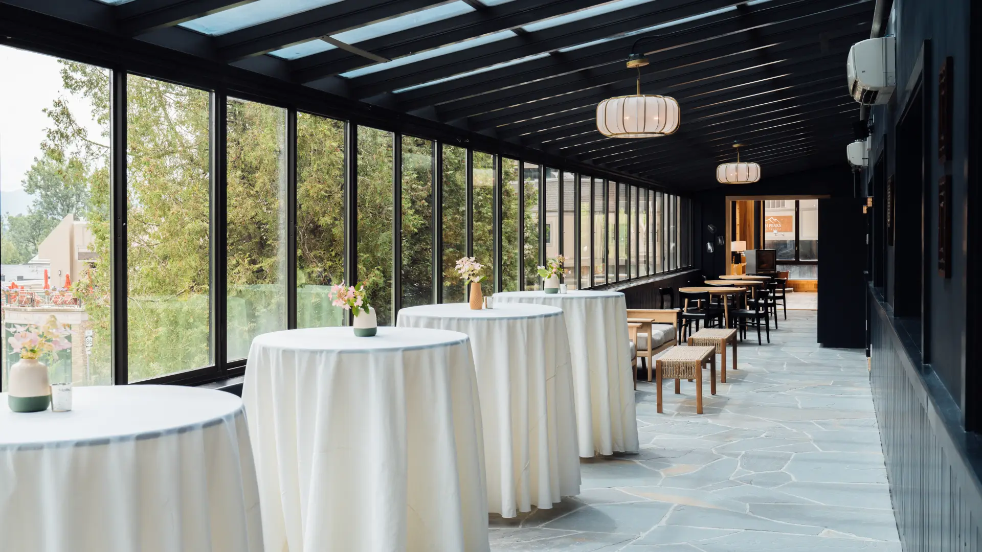 High tops in white linens under the solarium windows.