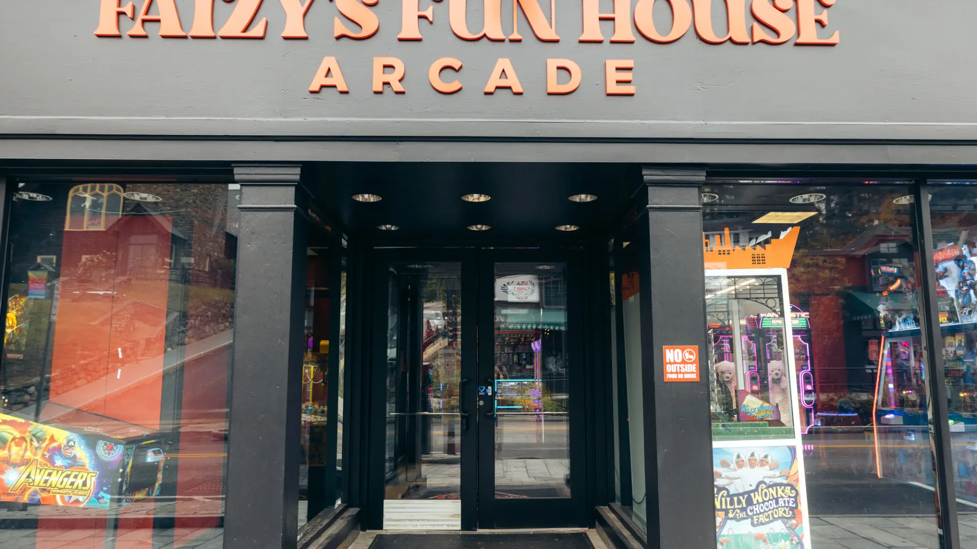The exterior of an arcade with large glass windows. The building reads, "Faizy's Fun House Arcade"