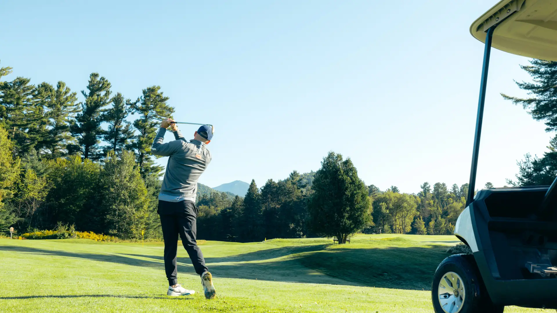 A man golfs on a green. 