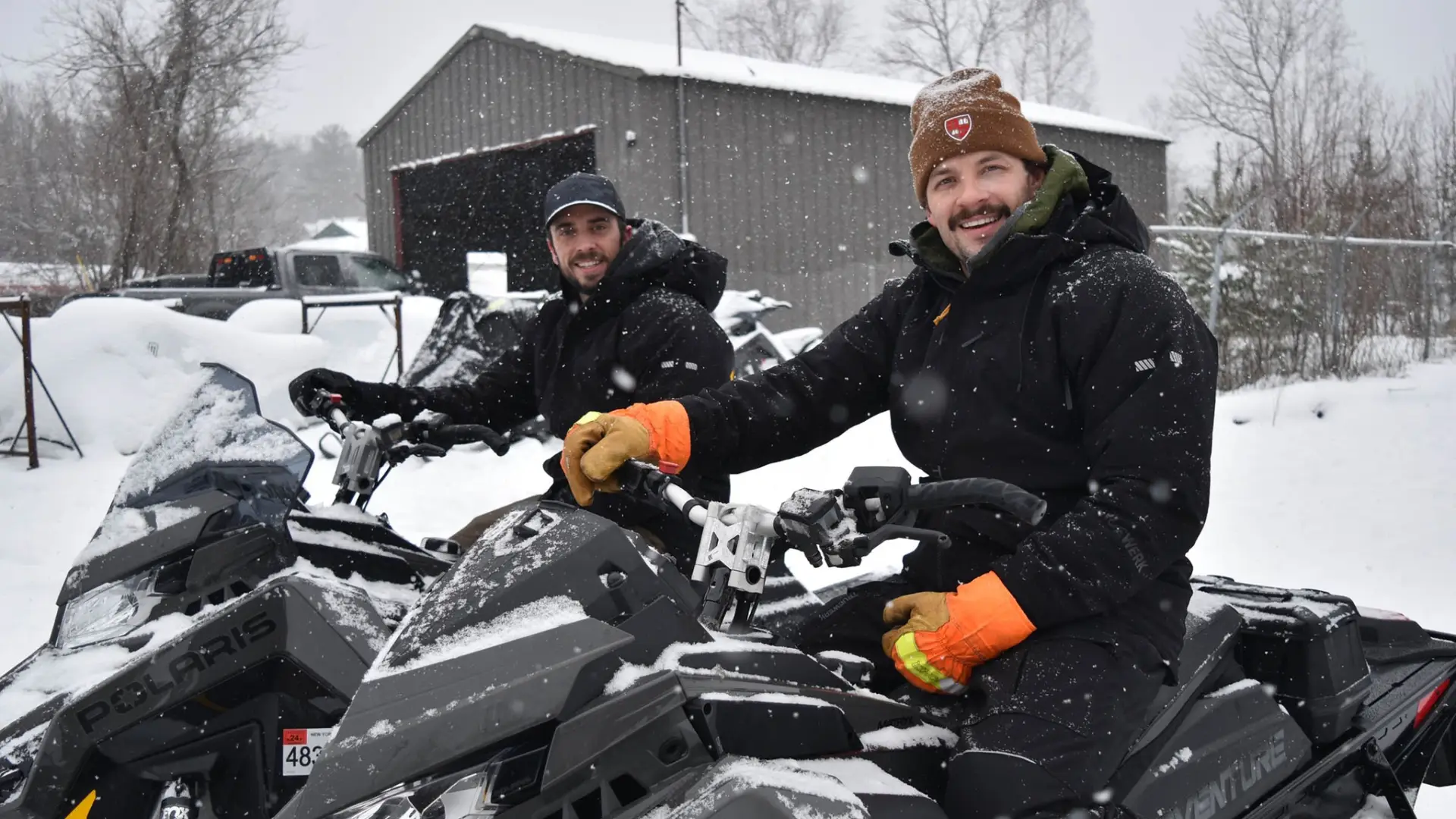 smiling faces atop polaris snowmachines