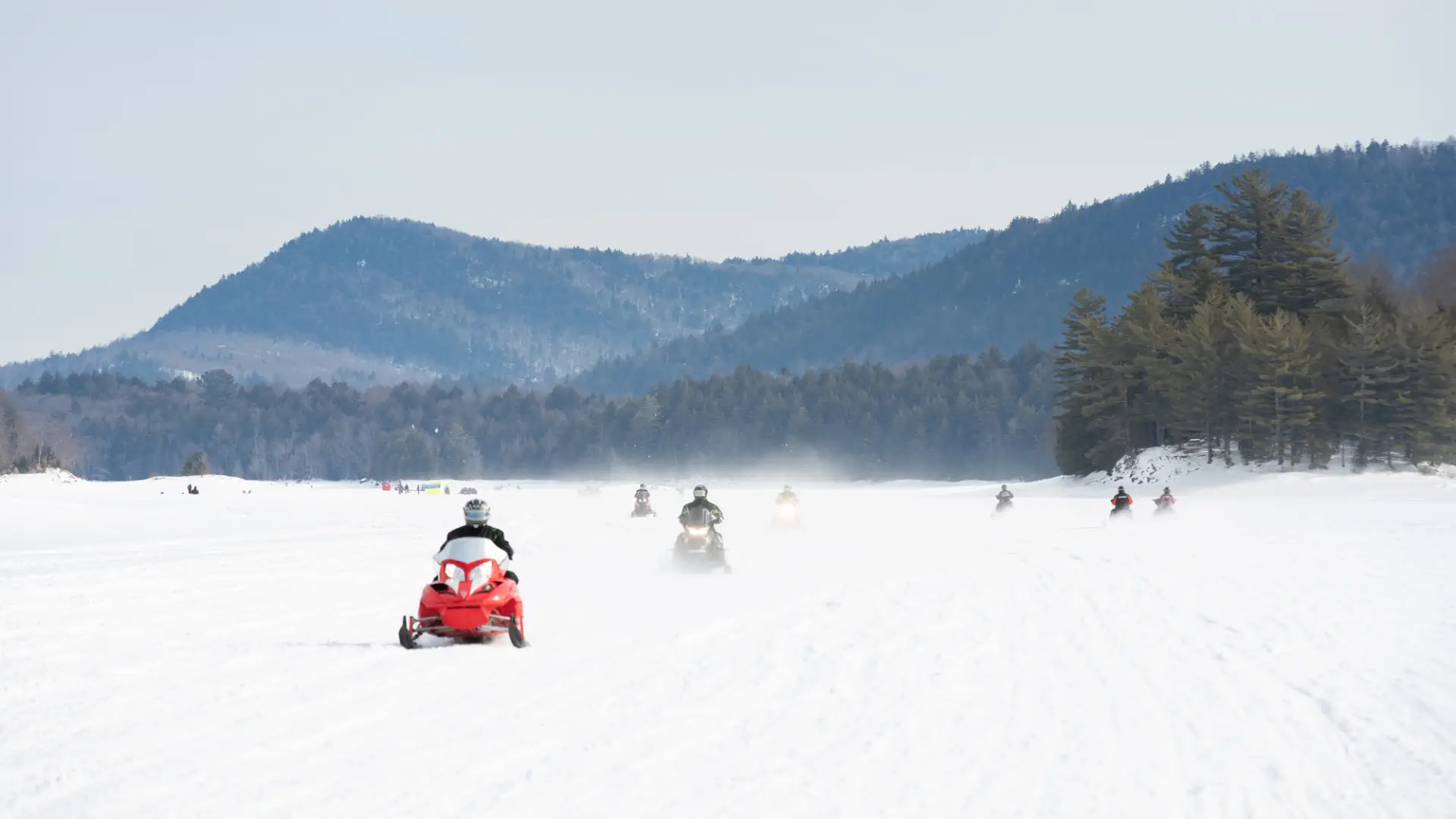 Snowmobilers on a frozen lake
