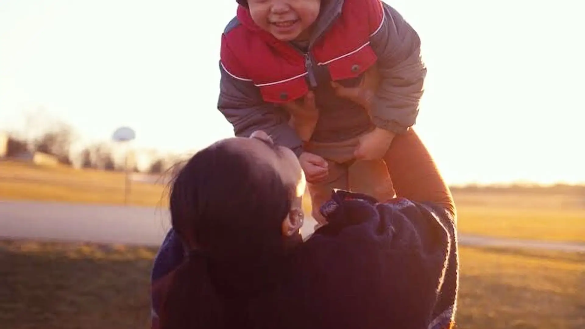 mother lifting her happy child in the air.