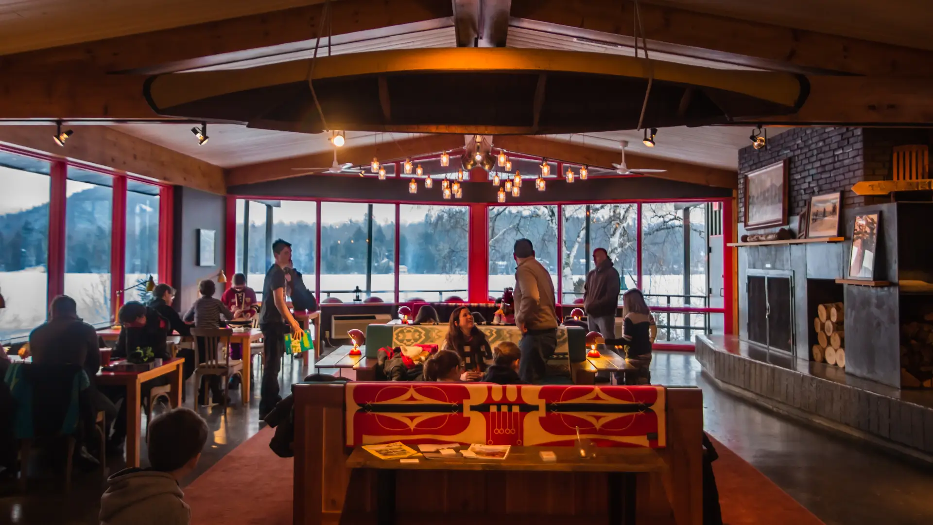 Great room of Lake House in Lake Placid in winter with families mingling near fireplace