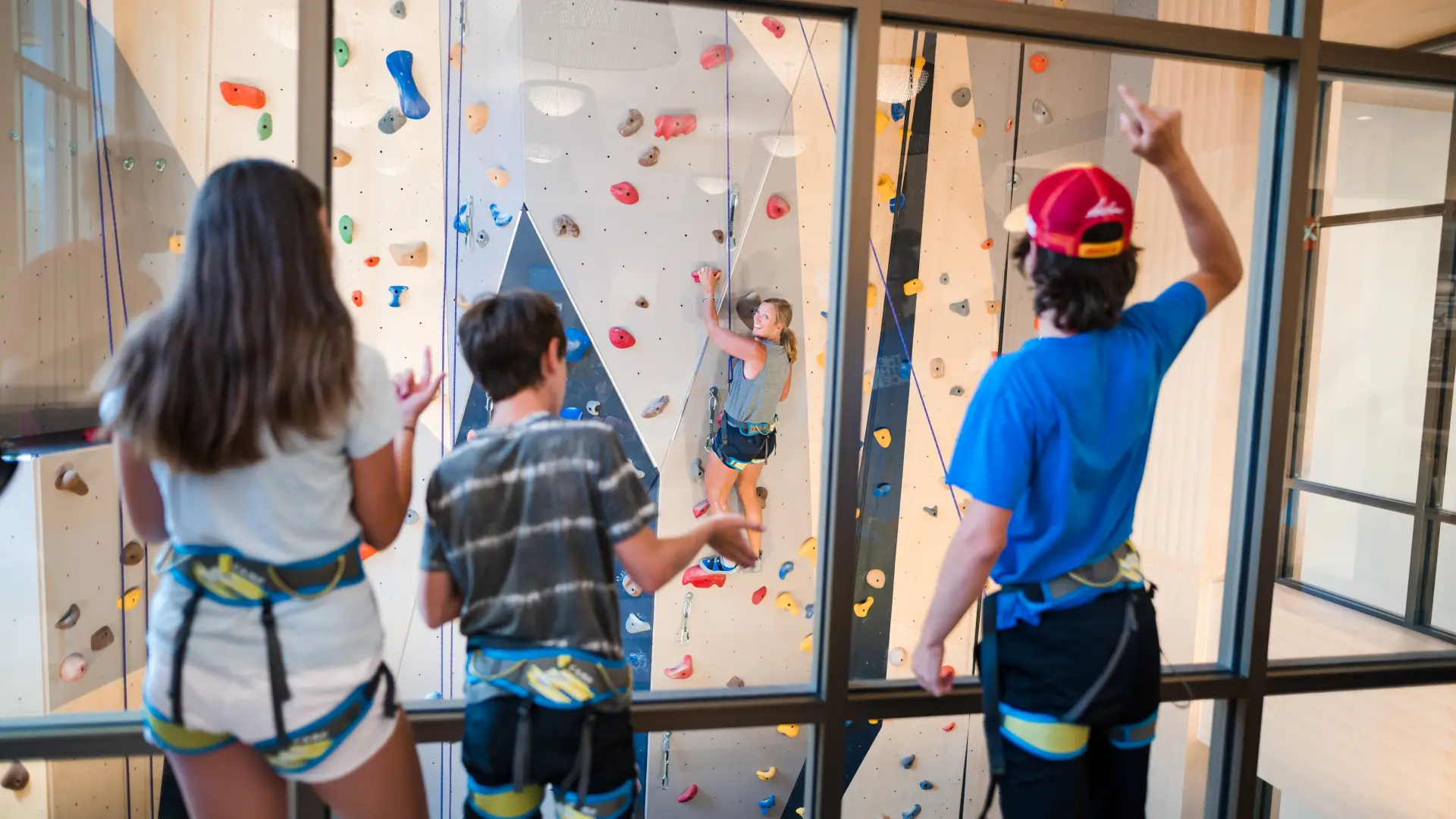 Family watches a family member climb the the climbing wall