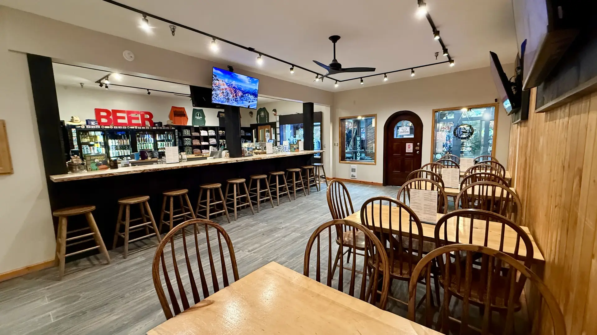 View from the far back corner of the dining space, bar area, coolers and swag shelves at Raquette River Brewing Taproom