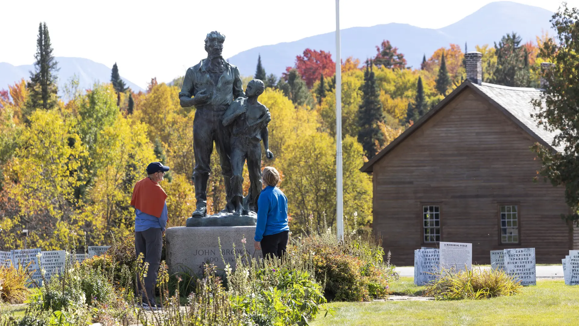Two people look at a metal statue of John Brown
