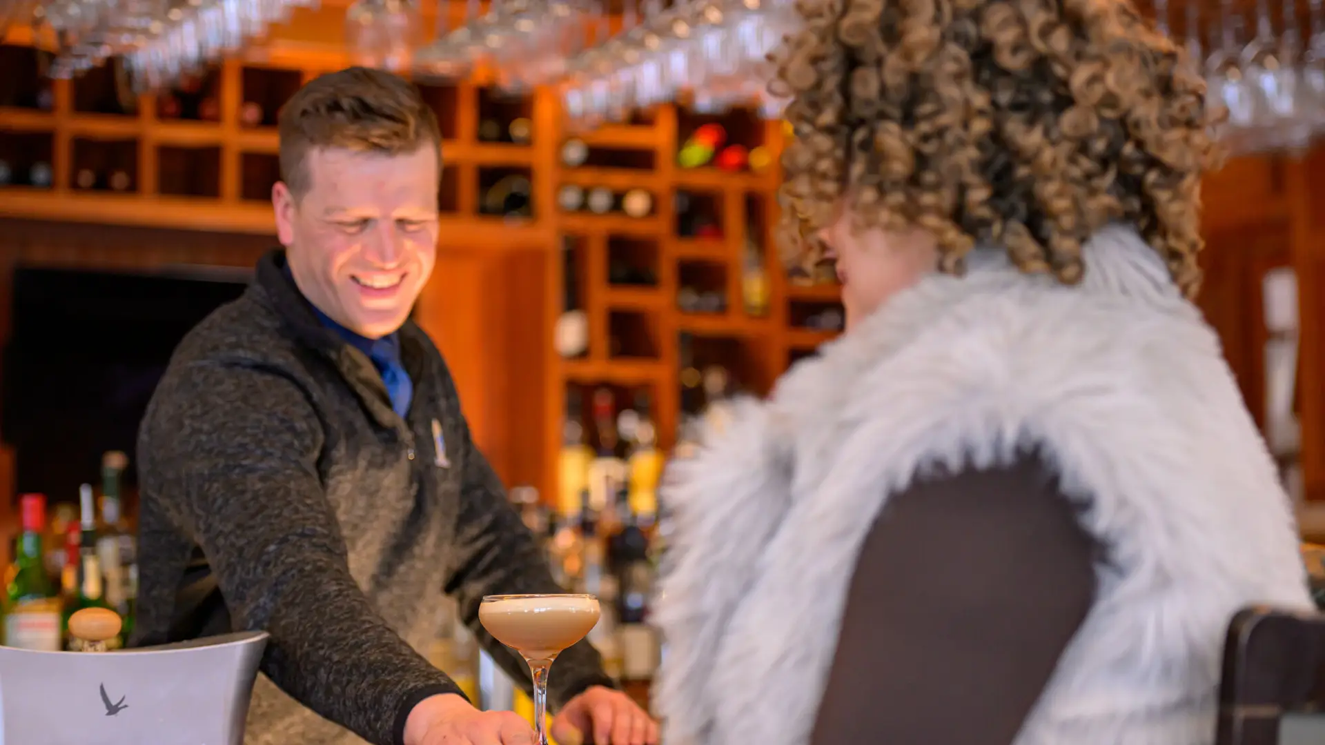 Bartender places drink in front of woman