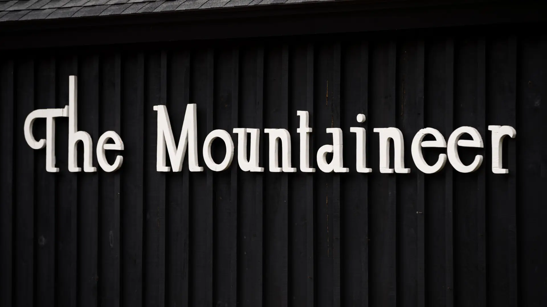 A white sign on a black background that says "The Mountaineer"