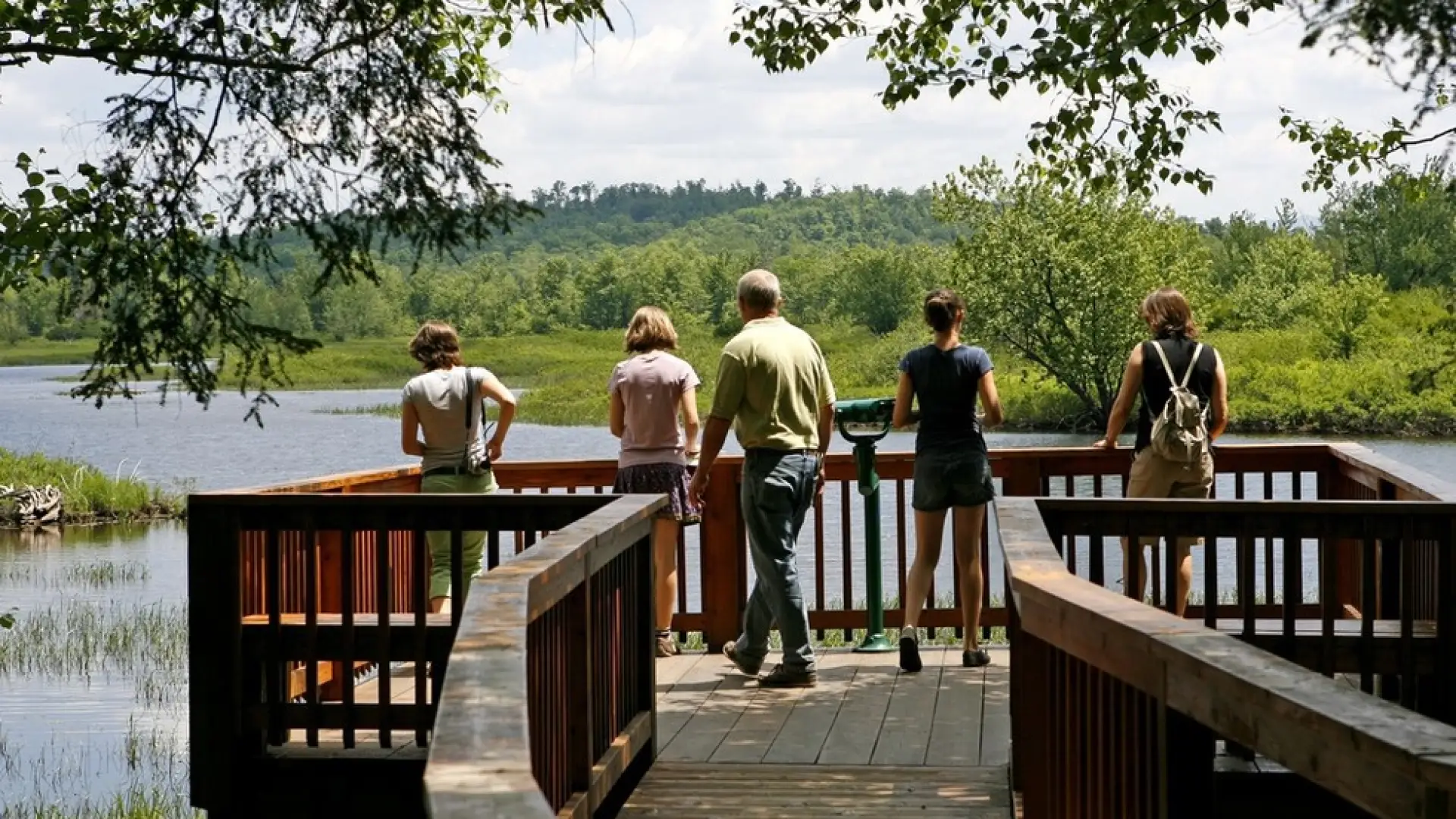 A family gazes out at the water from a large waterside structure