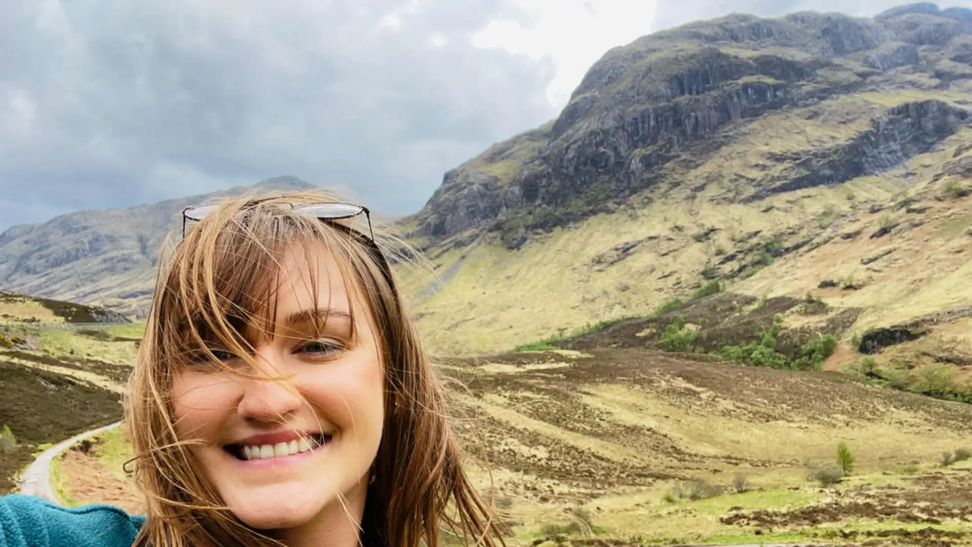 A selfie of a woman with a scenic background.