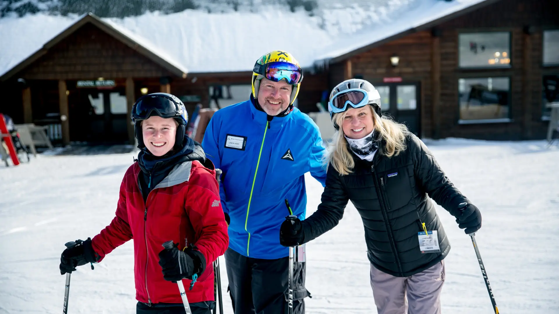 Three people posing after a ski lesson.